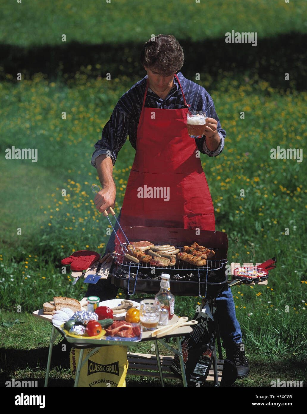 Meadow, man, barbecue, grill small sausage summer, side table, garden grill,  charcoal grill, food, prepare, cook, eat, food, meat, grill meat, sausages,  leisure time, beer glass, drink, outside Stock Photo - Alamy