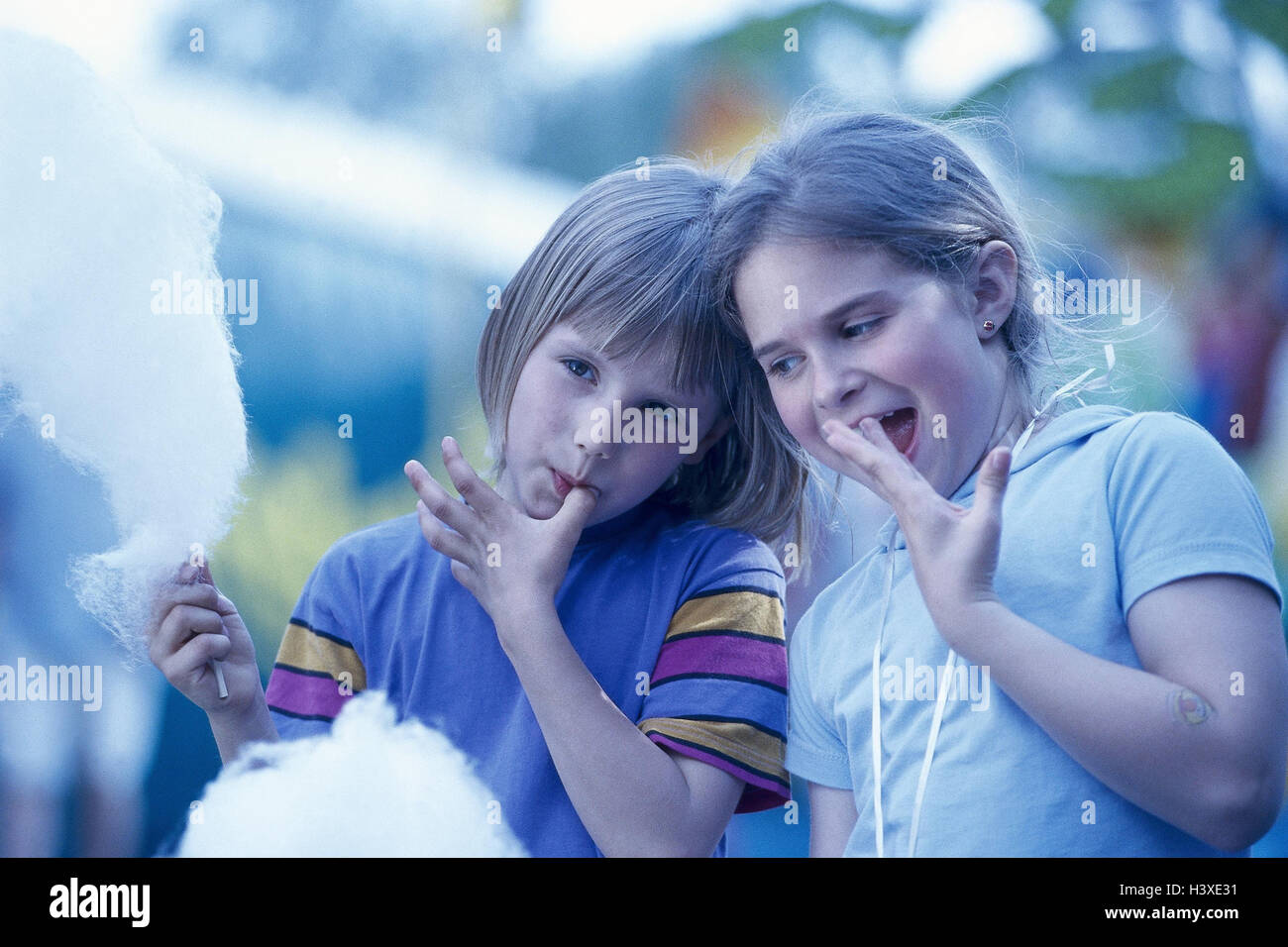 Girls, two, candy floss, eat, fingers, lick off, half portrait, children,  outside, children, sweets, friends, tasty, sweetly Stock Photo - Alamy