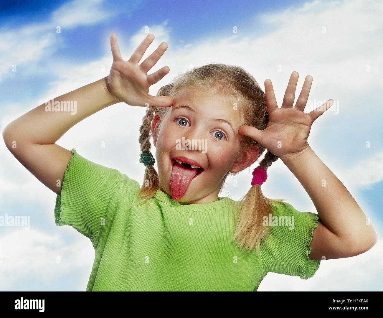 Girls, plaits, gesture, cheeky, tongue, point, portrait, children, studio, cut outs, boorishly, naughtily, child, annoy, grimace, stick out, perky Stock Photo