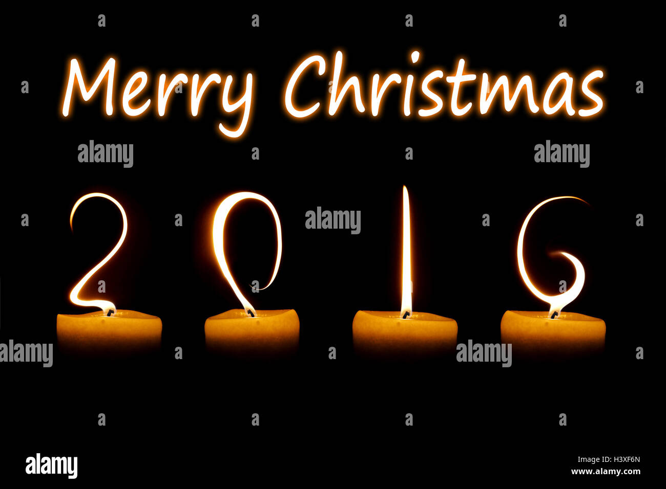 Merry Christmas 2016 written with candle flames on black background Stock Photo