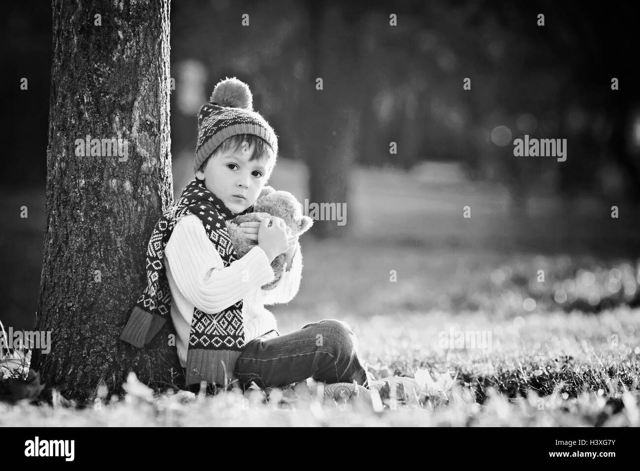 Adorable little boy with teddy bear in the park on an autumn day in the ...