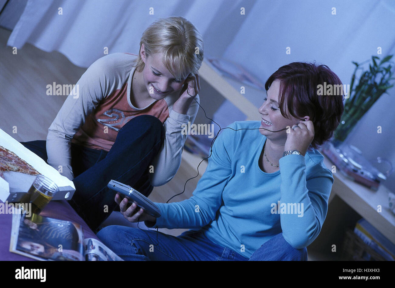 Sitting rooms, girls, floor, sit, hear Discman, music, model released, friends, teenagers, young persons, two, leisure time, leisure activity, CDïs, CD, entertainment eat pizza, Pizzaessen, happy, smile, fun, interest, magazine Stock Photo