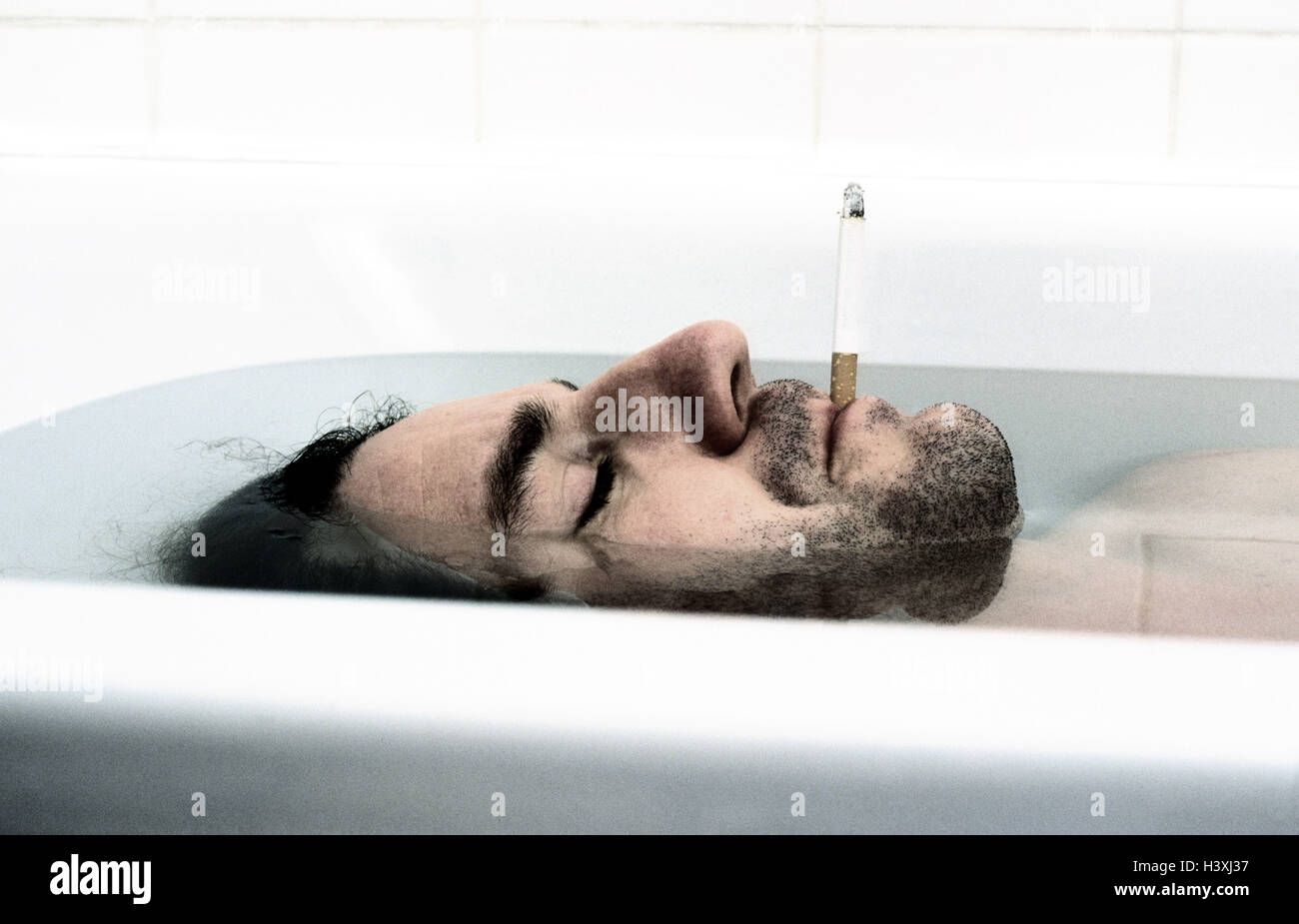 Man, bath, cigarette, relaxing, take it easy, tread, bath, have of a bath, hygiene, personal care, consumption, enjoy, pleasant sensation, well-being, ease, recreation, rest, switch off, water, dives, go down, smoke, smokers, dark-haired, unshaven, eyes closed, beard, side view, page portrait, 'can be done', lifestyle, detail, inside, very close, soul massage Stock Photo