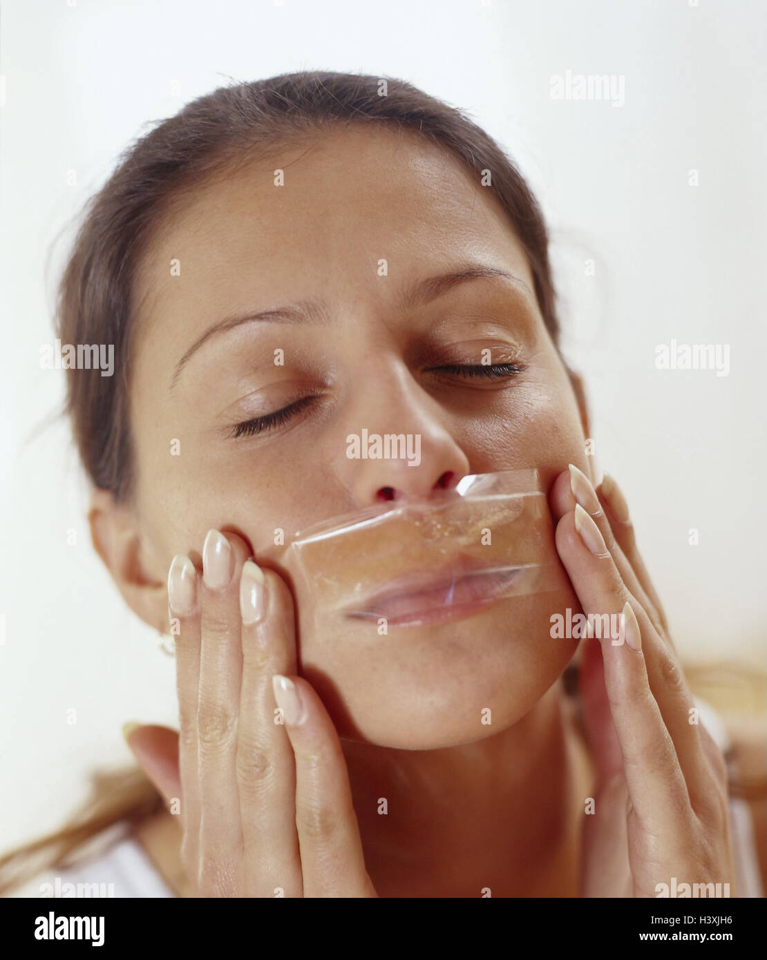 Woman, eyes closed, depilation, upper lip, wax film, portrait, model released, cosmetics, facial care, shell care, young, long-haired, brunette, epilation, removal, facial hairs, facial depilation, facial hair, wax, warm wax, cold wax film, depilation fil Stock Photo