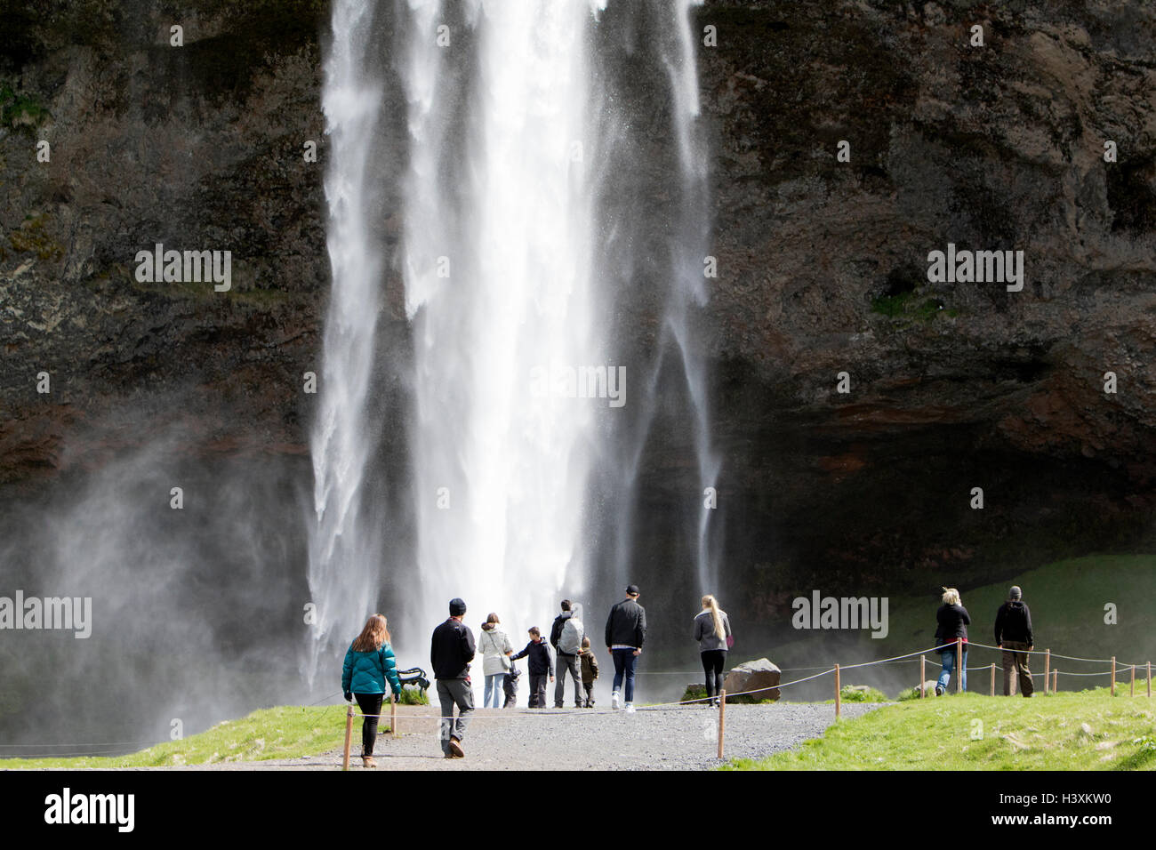 tourists in front of Seljalandsfoss waterfall iceland Stock Photo