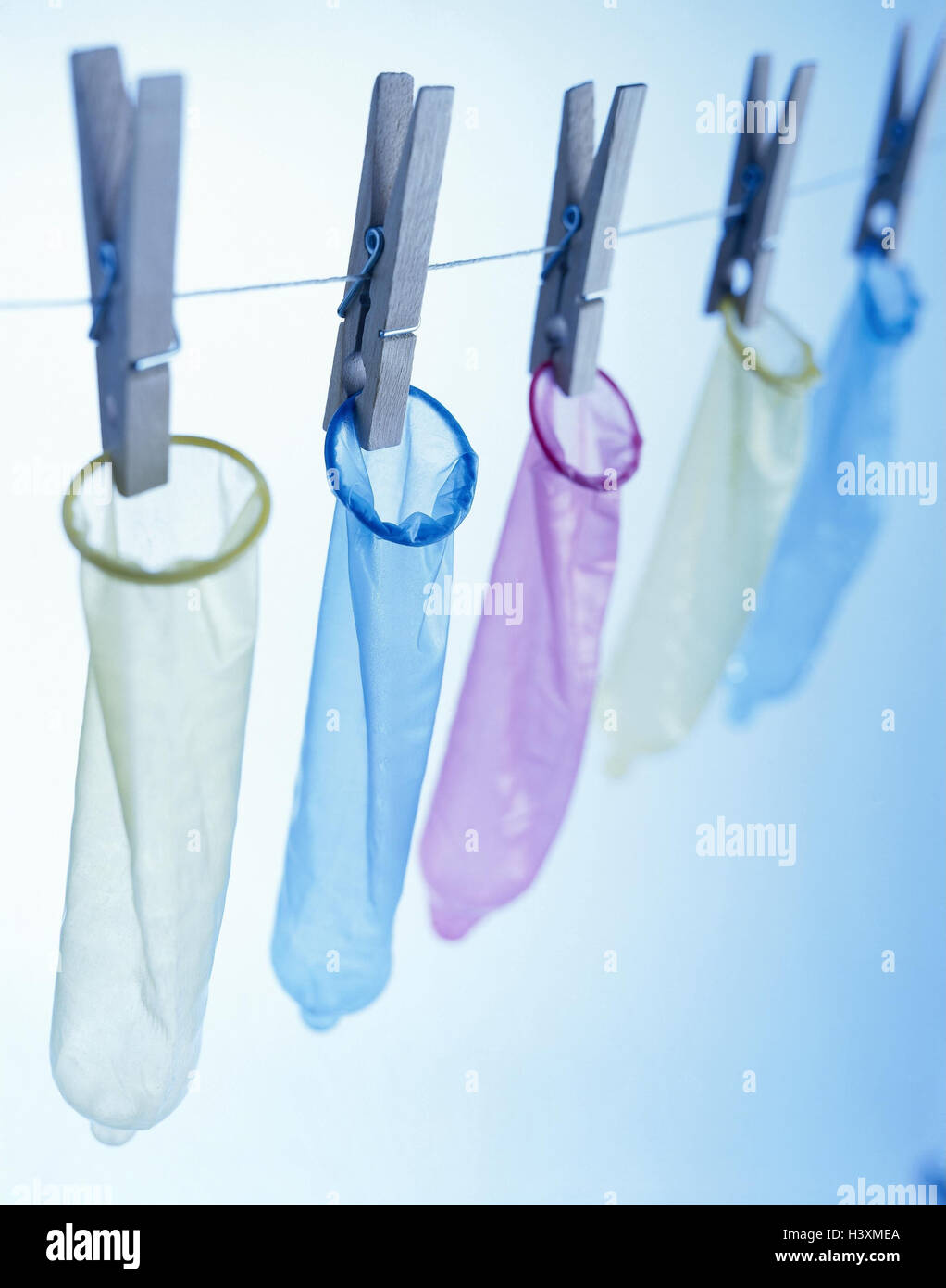 Clothesline, clamps, condoms, hang, Still life, product photography, studio, rope, cable, clothes pegs, prevention, security, contraception, condom, AIDS risk, danger infection, disease, protection, health, colours, differently, brightly, spectral filters Stock Photo
