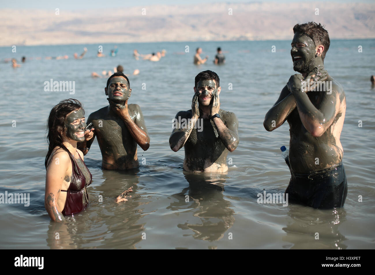 Bathers in the Dead Sea cover themselves in mud, which is reputed to have beneficial effects for the skin. From a series of phot Stock Photo