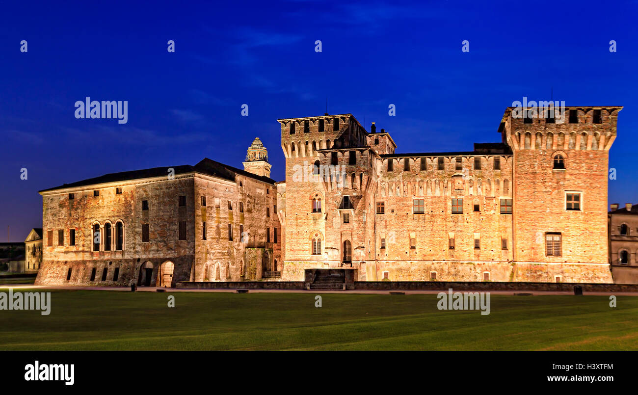 Italy Mantua Palazzo Ducale and ancient medieval castle walls and towers at sunset front view with illumination Stock Photo