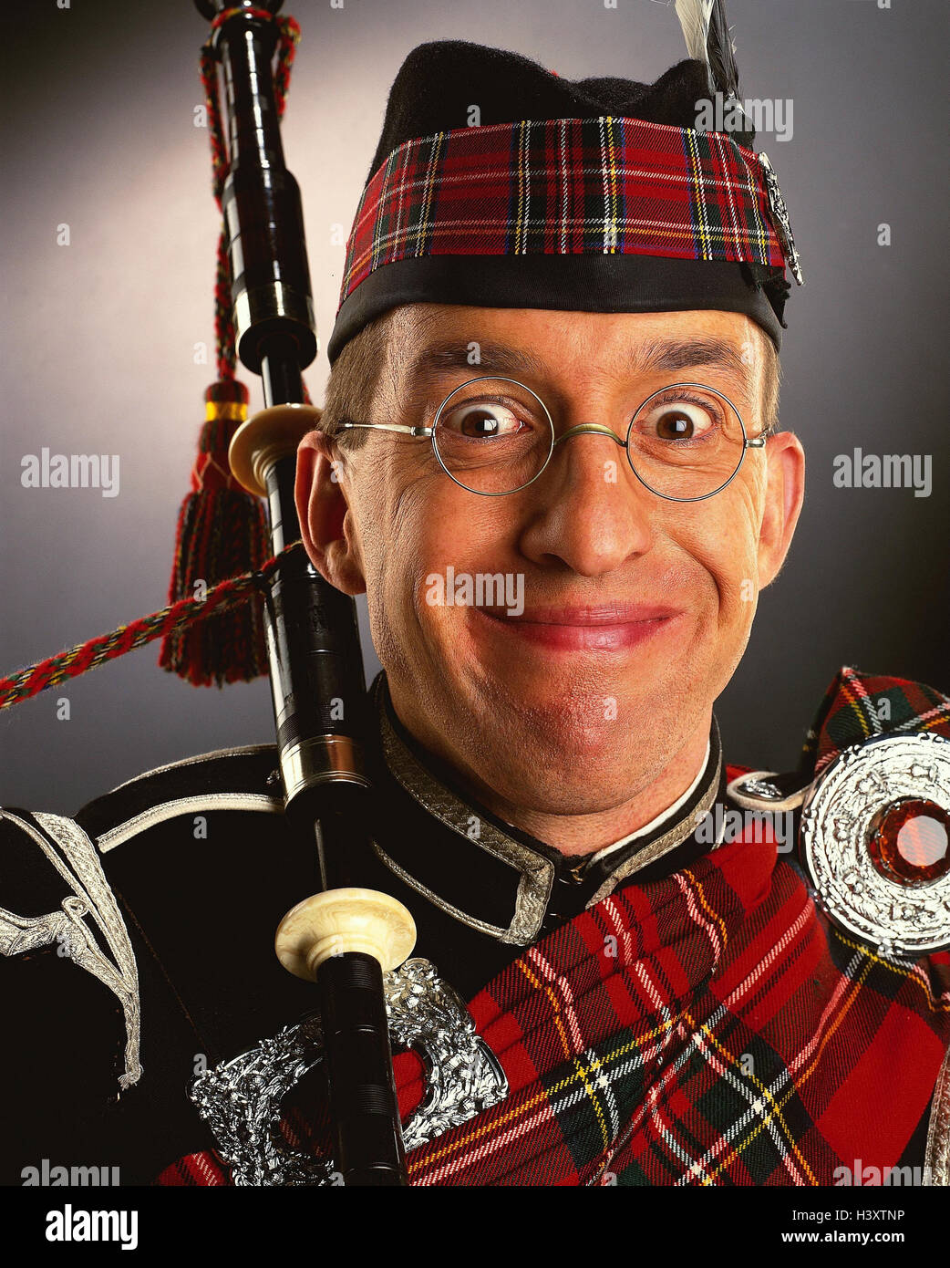 Scot, glasses, to bagpipes, facial play, portrait, concepts, Scotland, man, musical instrument, clothes, headgear, tradition, checked, smile, grin, grimace, happy, is surprised, studio, Stock Photo