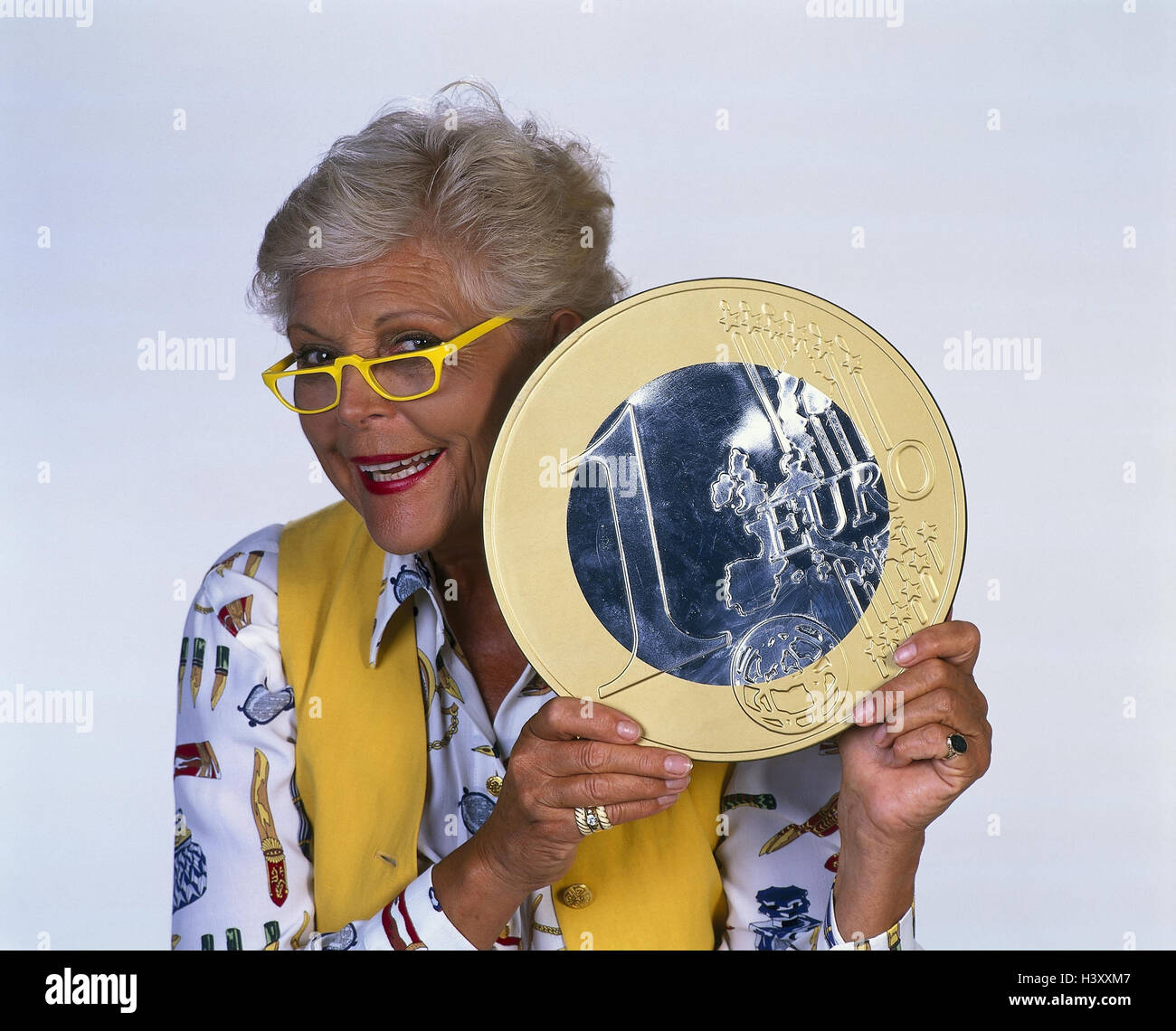 Senior, euro coin, outsize, point, portrait, woman, glasses, yellow, present, euro, currency reform, currency, money, means payment, introduction, changeover, coin, colossally, studio Stock Photo