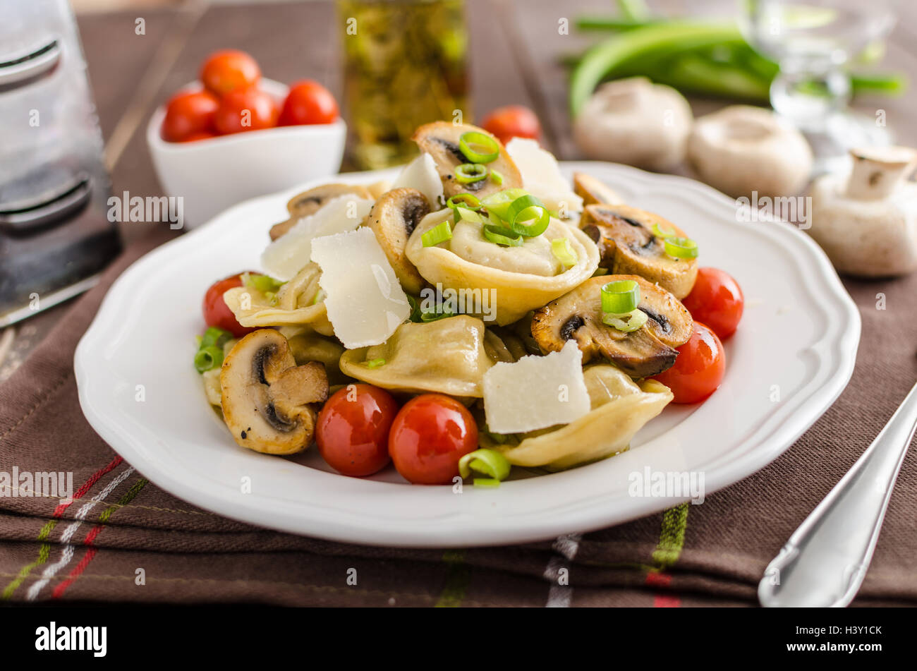 Homemade tortellini stuffed with mushrooms and spring onion, roasted tomatoes, garlic souce