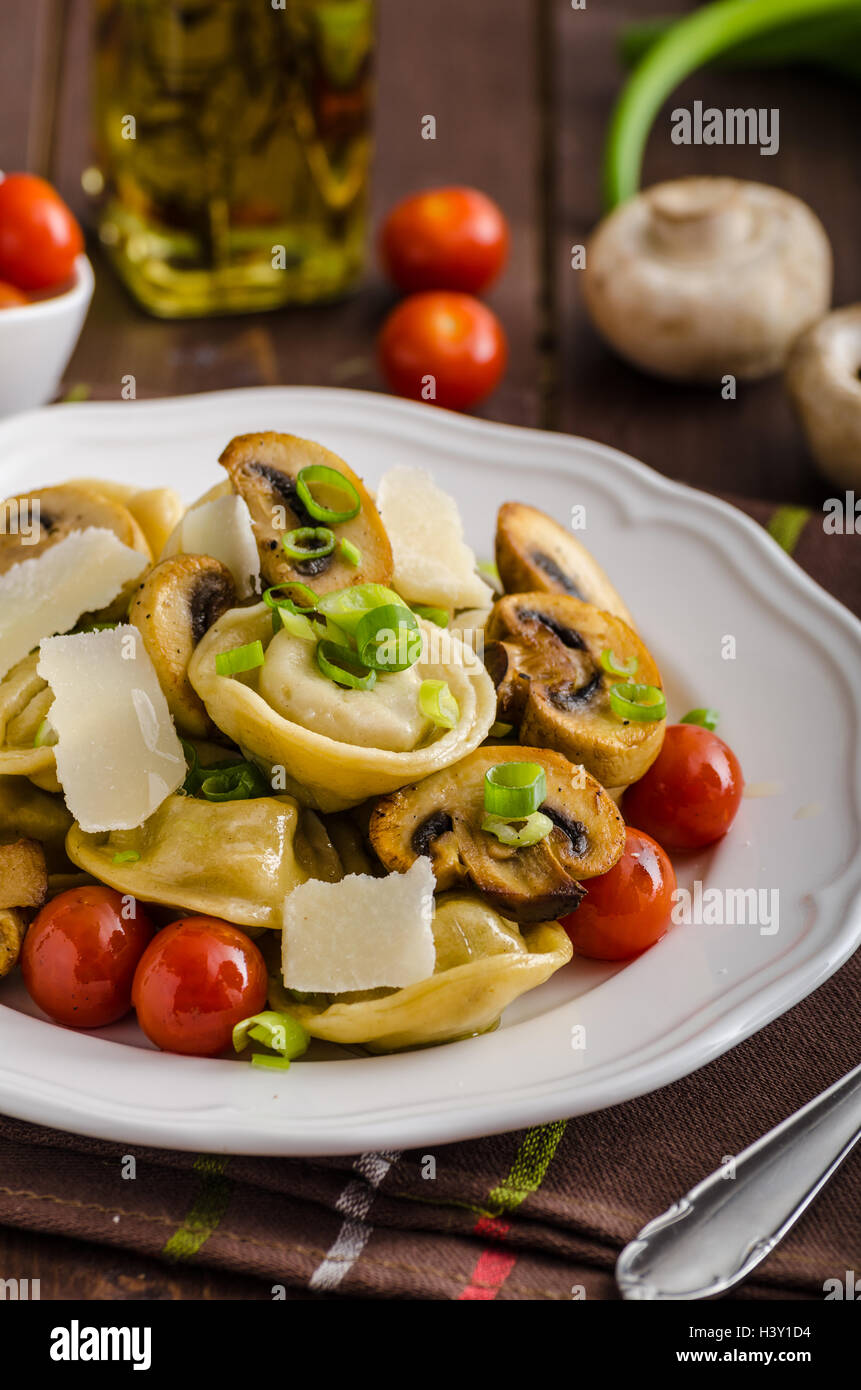 Homemade tortellini stuffed with mushrooms and spring onion, roasted tomatoes, garlic souce