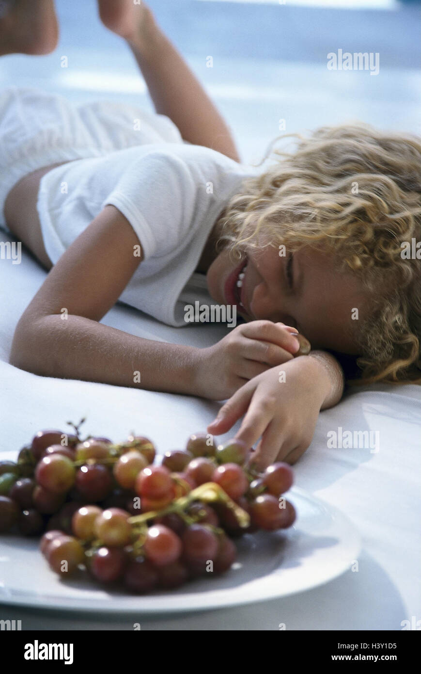 Girls, happy, lie, plates, grapes child, blond, curls, inside, bed ...