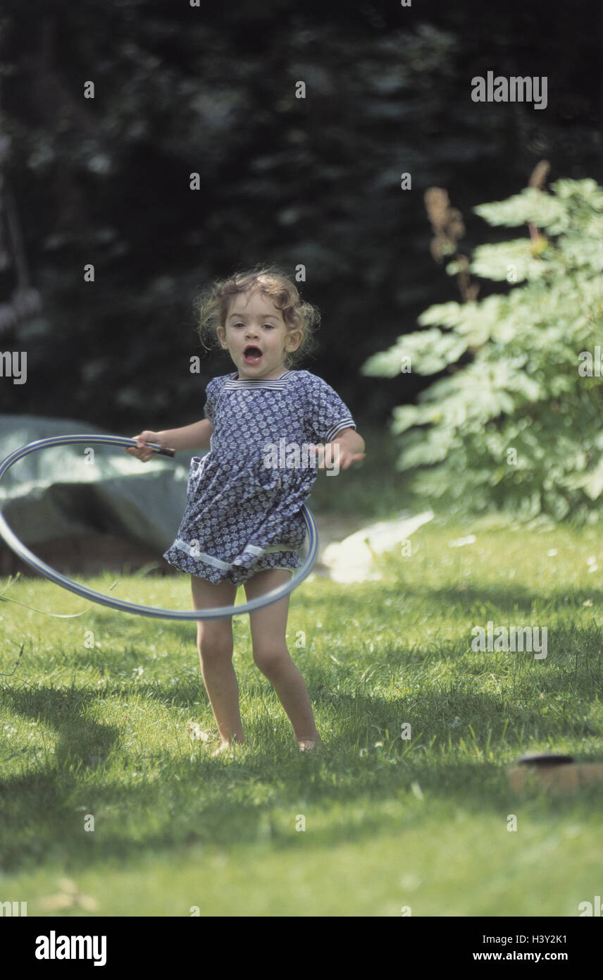Garden, girl, melted, hula Hoop tyres, play, outside, holidays, leisure time, childhood, child, infant, 3 years, game, hula Hopp tyre, Hula-Hoop, Hula-Hopp, motion, skill, quickness, happy, fun, mood, positively, summer Stock Photo