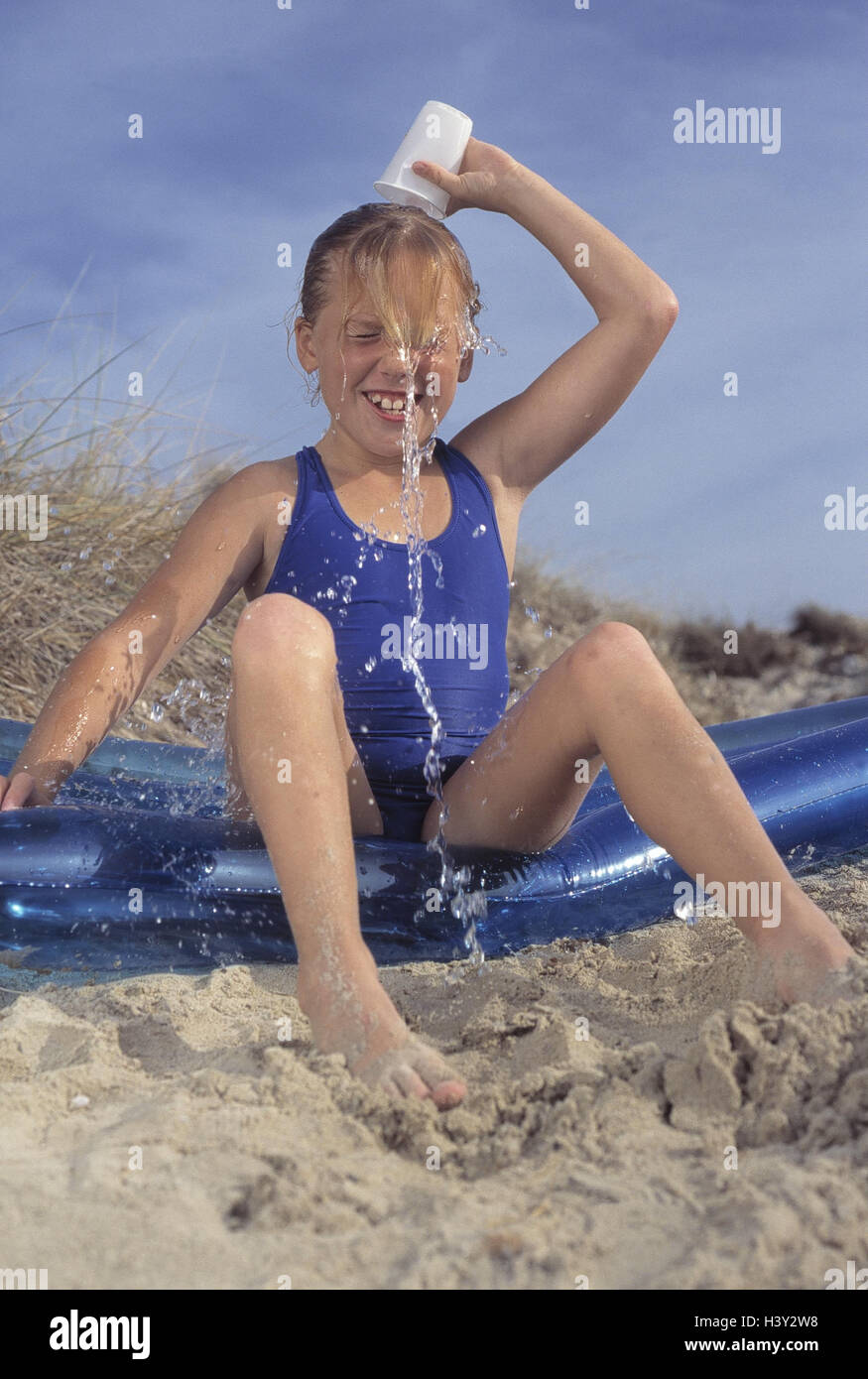 Air bed, girl, sit, pour over mug, water, detail, outside, summers, leisure time, childhood, vacation, holidays, beach, sandy beach, fun, smile, cool, happy, 9 years, cooling, refresh, refreshment, mug, swimsuit, swimwear, very close Stock Photo