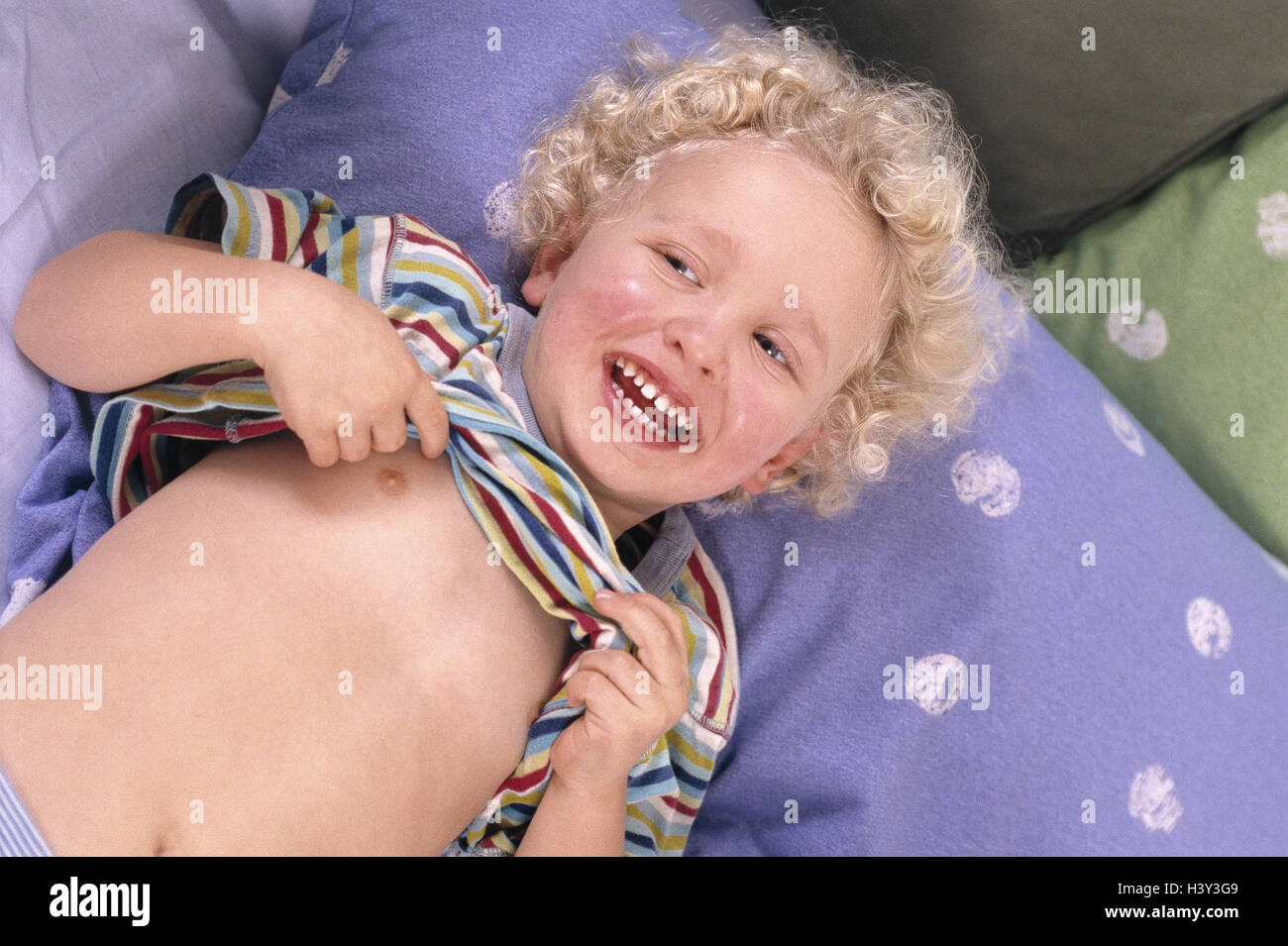 Bed, boy, lie, pull up T-shirt, laugh, model released, at home, child, happy, cheerfulness, giggle, amuse cheerfully, cheerfulness, fun, funnily, mood, positively Stock Photo