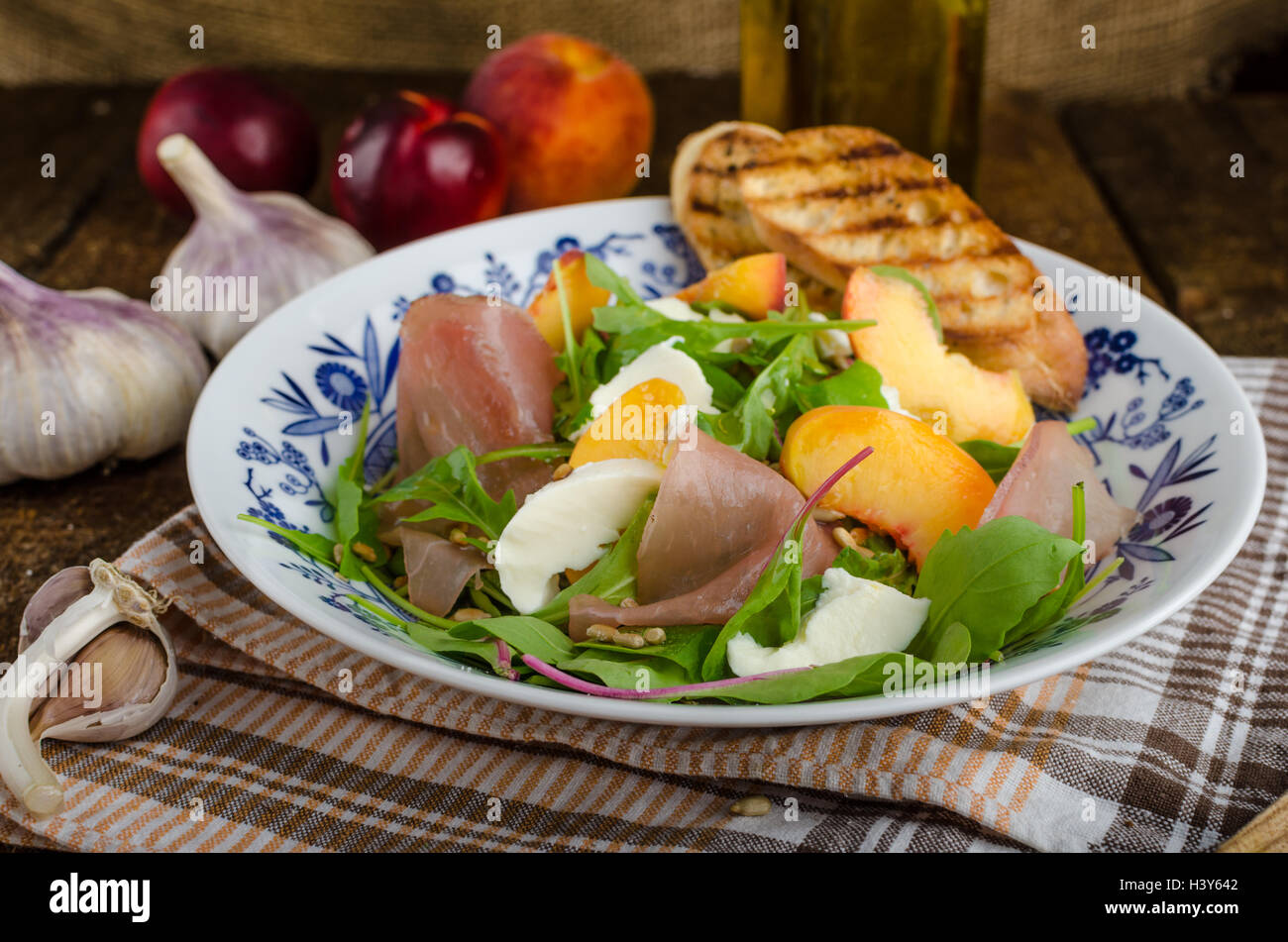 Rocket salad with prosciutto, mozzarella and peaches, panini baguette