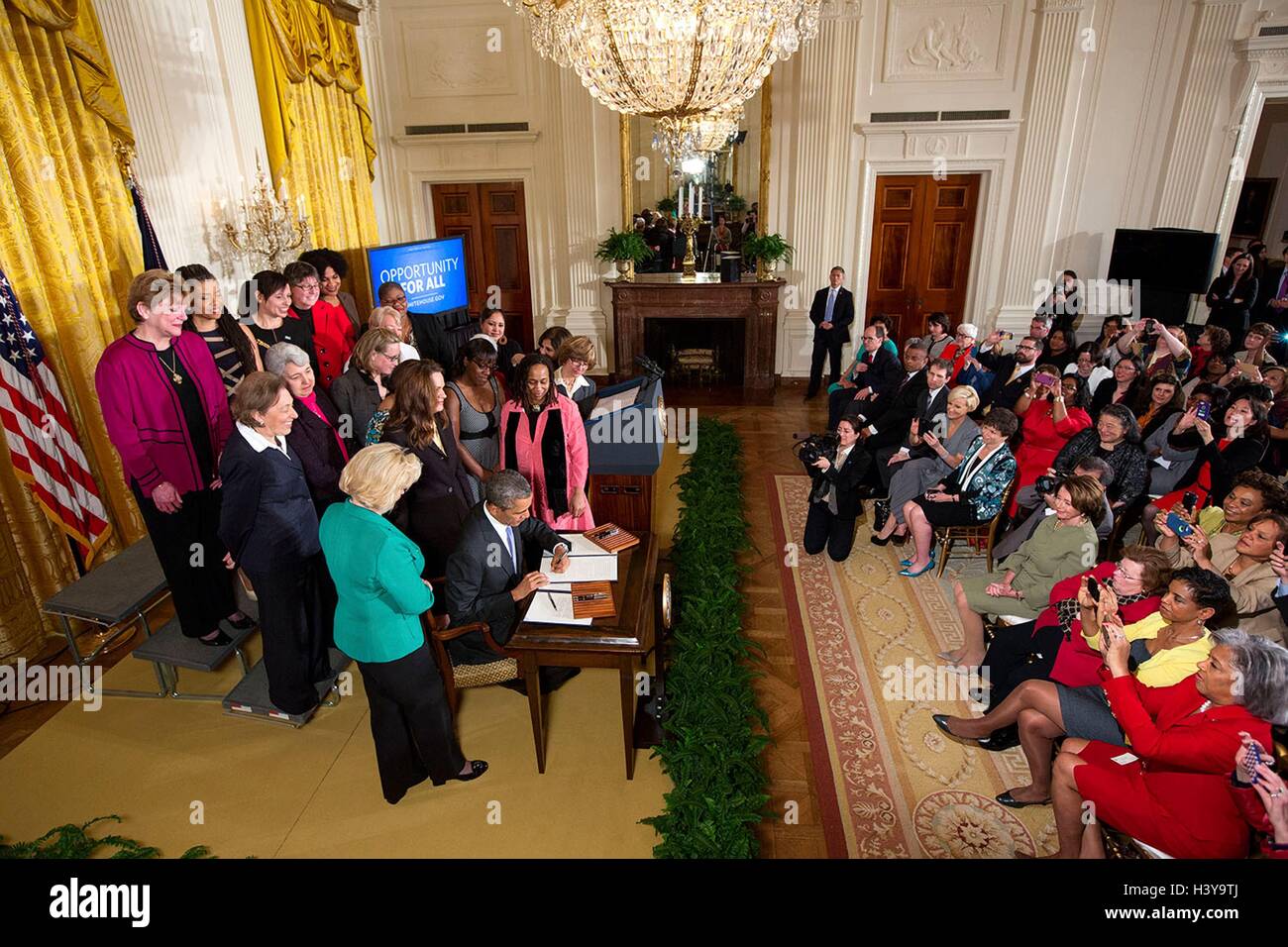 U.S President Barack Obama signs executive actions to strengthen enforcement of equal pay laws for women, at an event marking Equal Pay Day in the East Room of the White House April 8, 2014 in Washington, DC. Stock Photo