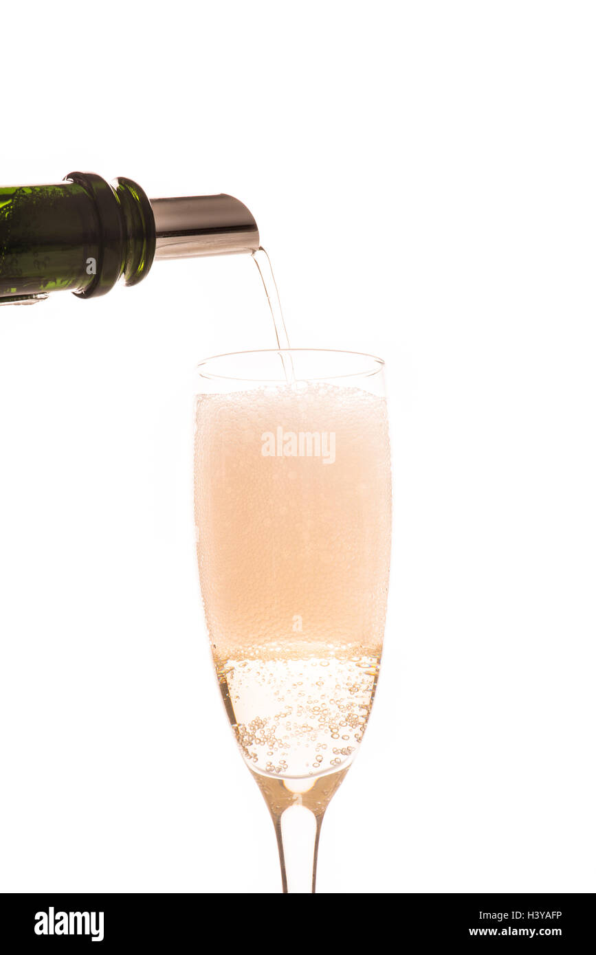 Pouring sparkling white wine with drop stop spout in champagne glass. Concept of celebration, party or festive drink. Stock Photo