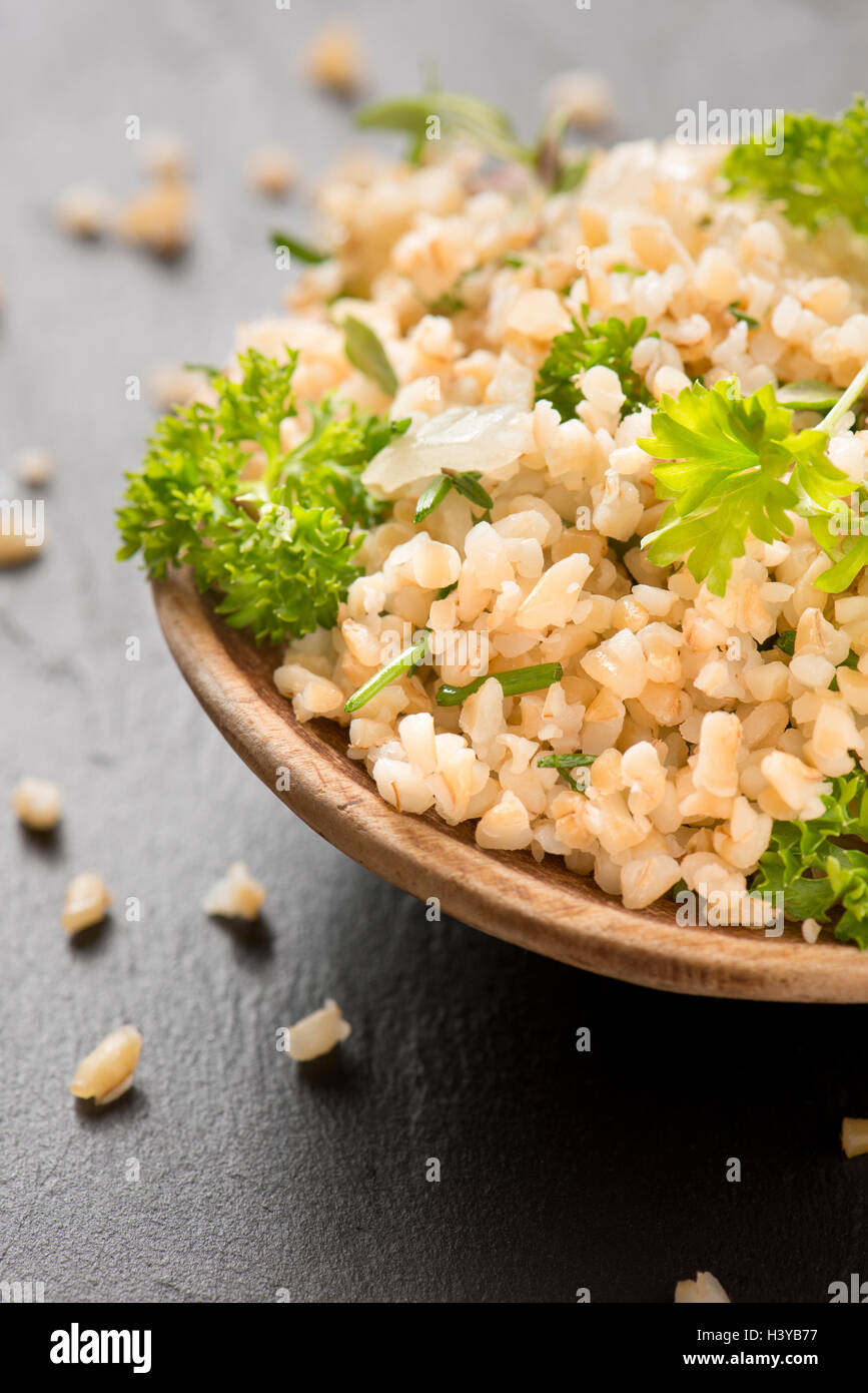 Bulgur with fresh herbs in close up. Fresh and healthy vegetarian or vegan food. Stock Photo