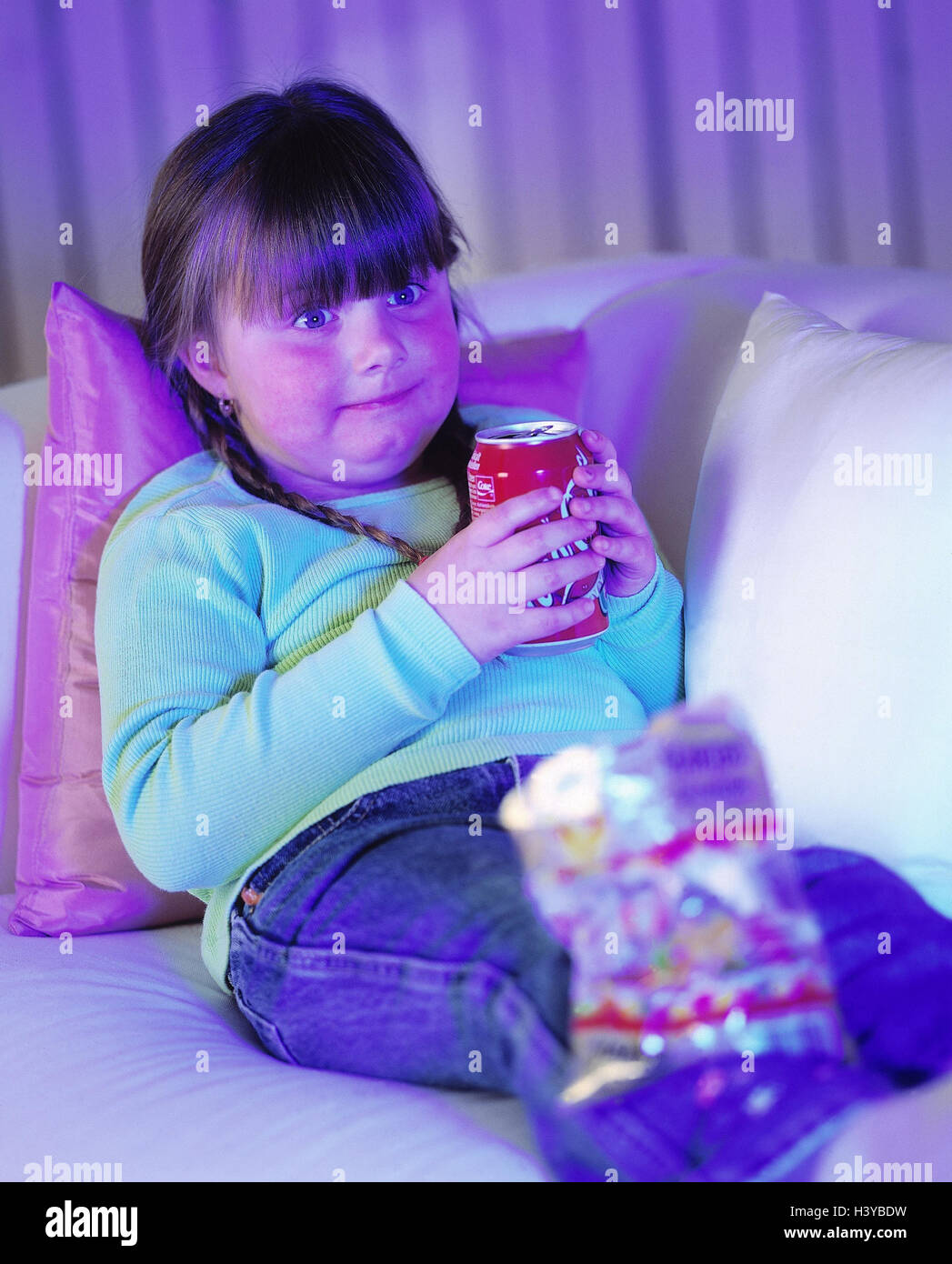 Sofa, girl, thickly, coke, drink, little elastic bears, inside, at home, watch TV, child, overweight, nutrition, unhealthily, calories, rich in calorie, drink, caffeine, caffeine-containing, sweetly, sweet, sweetness, containing sugar, bag, Gummibärchentü Stock Photo