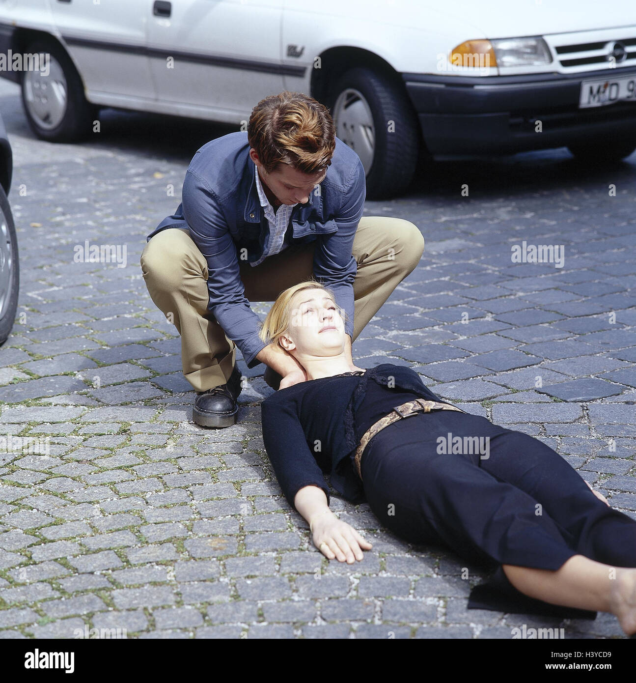 Traffic accident, woman, lie, help street, first assistant, accident, accident help, injured persons, accident victims, back position, first help, first aid, medicine, man, control, head, napes, support Stock Photo