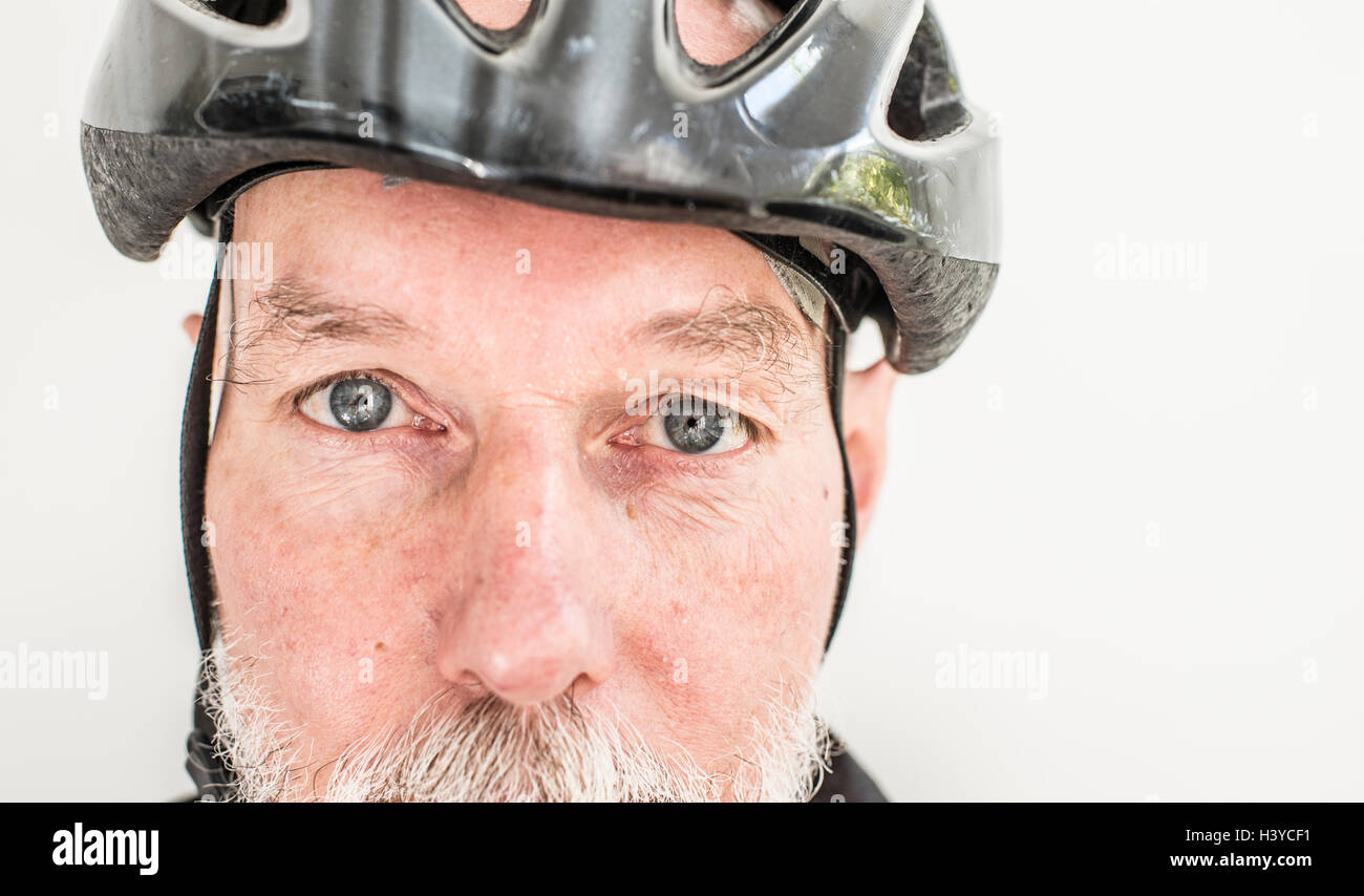 Close up of old man wearing a bicycle helmet. Portrait of elderly person living an active life with healthy lifestyle. Stock Photo