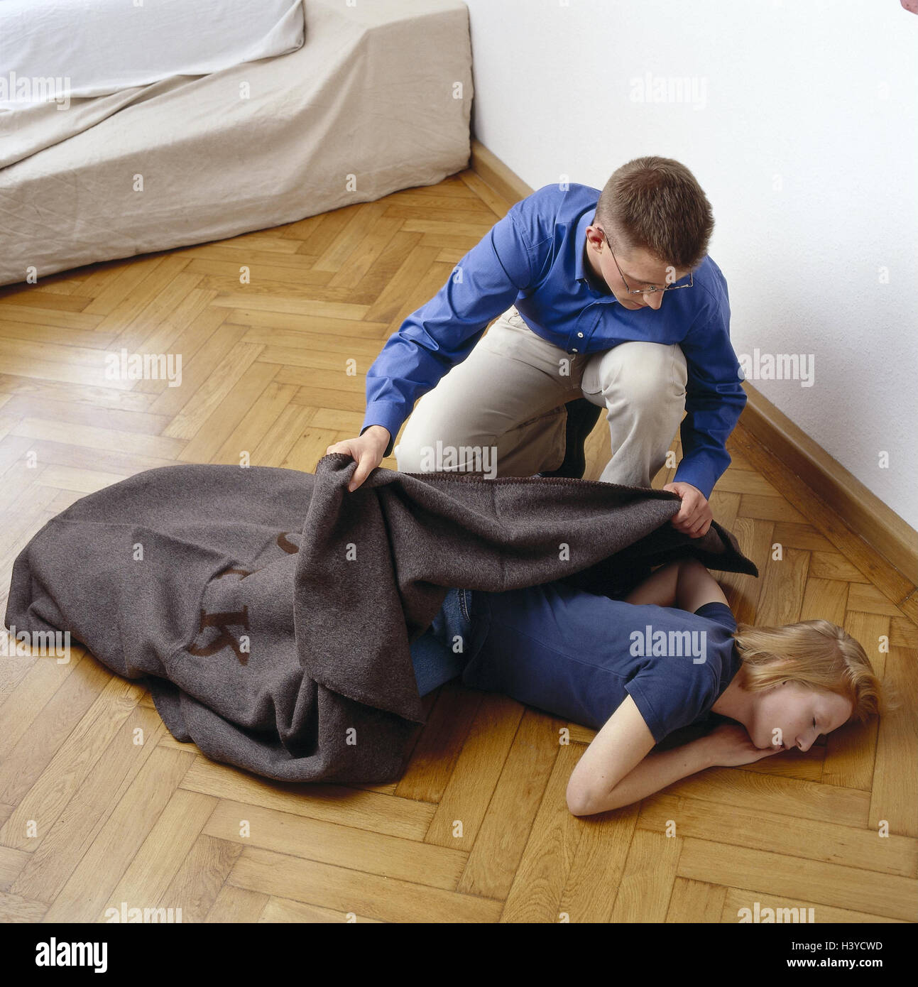 Woman, floor, lie, help unconsciously, man, first supply, woollen blanket, injured persons, accident victims, first help, first aid, medicine, first assistant, stable page position, faint, in need care, care, supply, inside Stock Photo