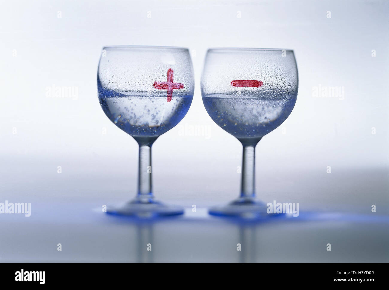 Water glasses, expression, 'The glass are half-filled - the glass is half-empty', Still life, product photography, glasses, label, marks, paints, figures, icons, plus, below, +, - mineral water, drink, drinking, alcohol-free, anti-alcoholic, weigh, assess Stock Photo