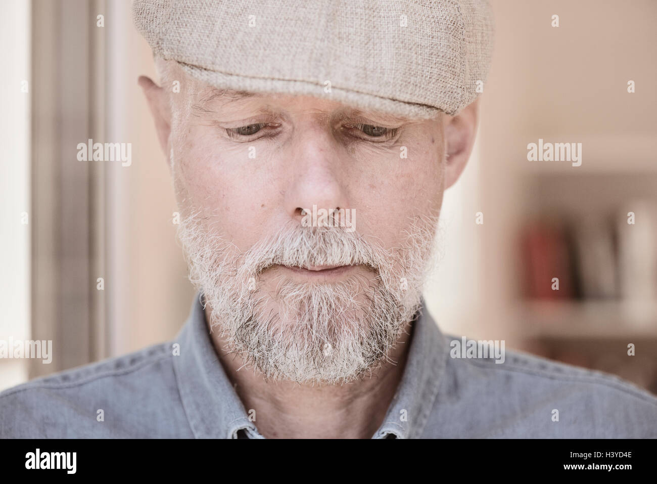 Portrait of old man looking down. Serious and pensive facial expression. Stock Photo