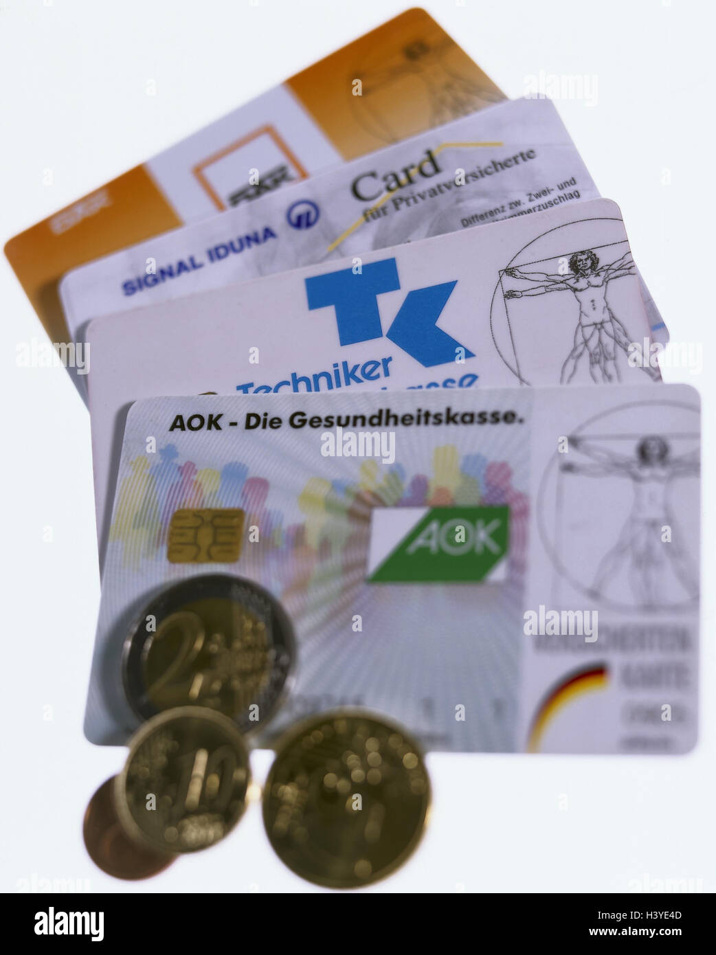 Health insurance cards, health insurances, differently, euro coins public health, health insurance, insurance cards, insurance cards, expenses, cost projection, increase in contributions, rise in price, money, coins, copy spaces, Still life Stock Photo