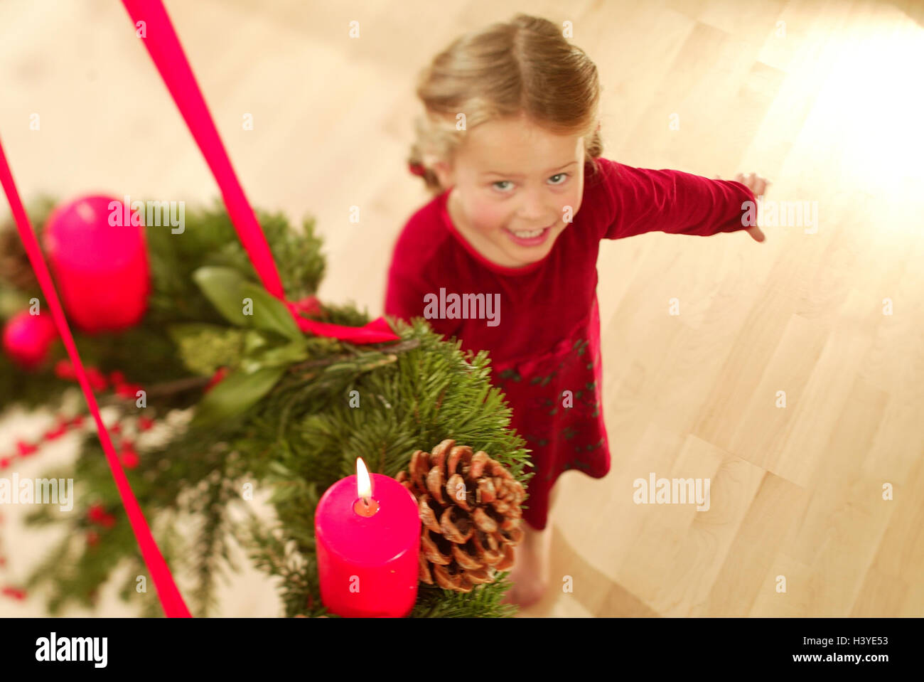 Girls, gesture, view up, Advent wreath, hang, from above, inside, at home, child, 6 years, Christmas, yule tide, for Christmas, Advent season, candle, burn, prejoy, joy, expectation, expectantly, happily, indicate, testify, point, smile, Advent candle Stock Photo