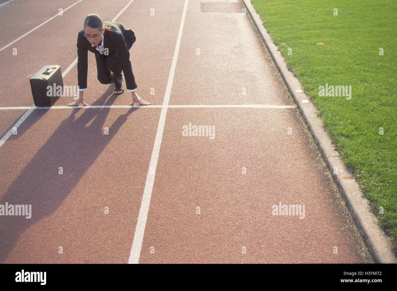 Dirt track, businesswoman, start position, briefcase, evening light, occupation, business, Tartanbahn, woman, manager, suit, career woman, glasses, briefcase, start, race, way to the success, ready for launch, ambitiously, energetically, purposefully, fut Stock Photo