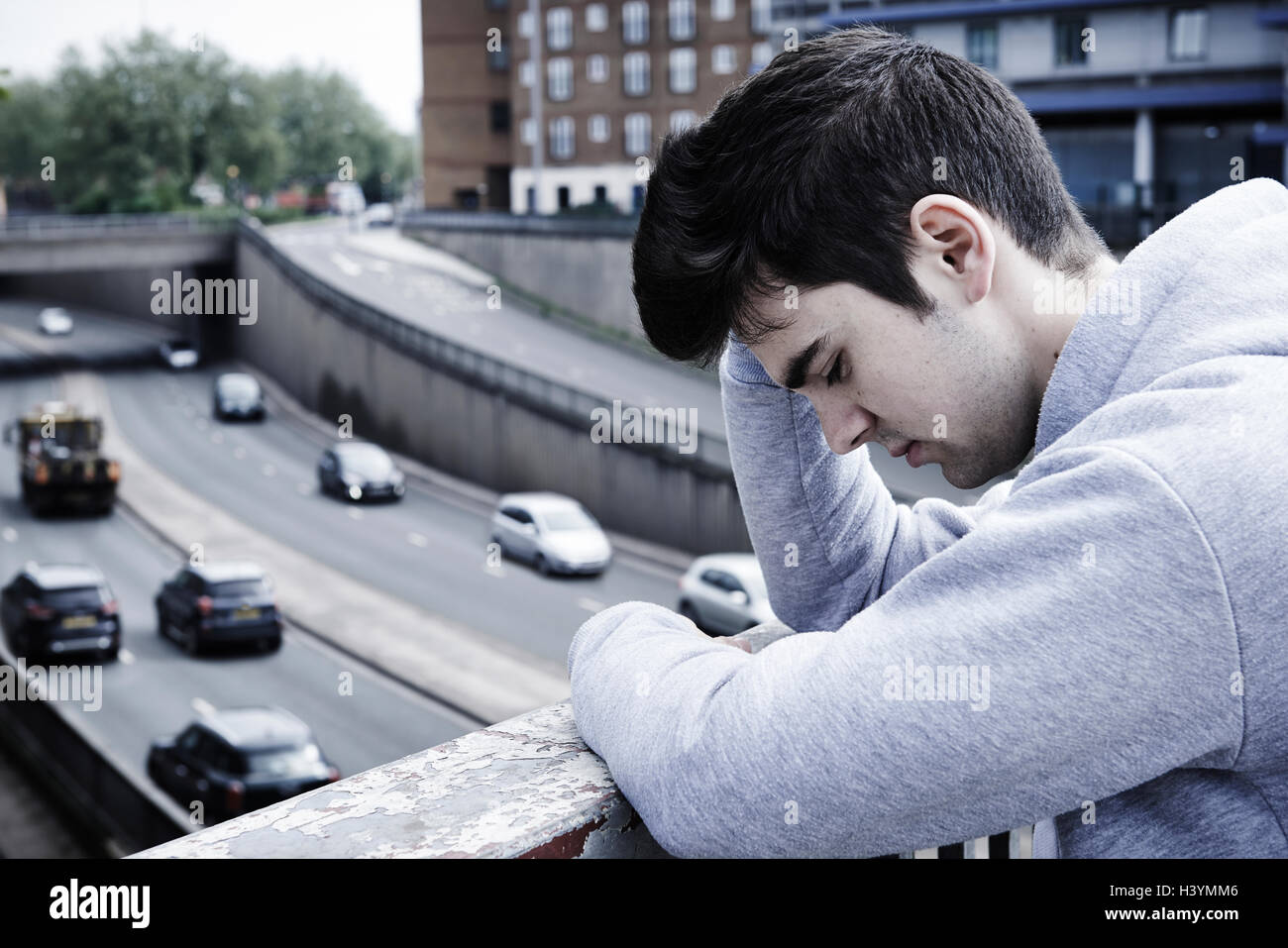 Depressed Young Man Contemplating Suicide On Road Bridge Stock Photo