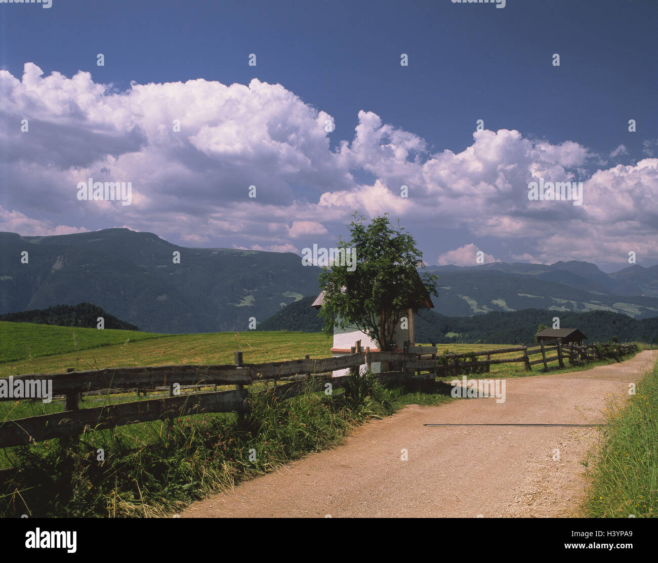 Italy, South Tyrol, Kastelruth, country lane, band, cloudy sky, band, country lane, mountains, fence, meadow, outside Stock Photo