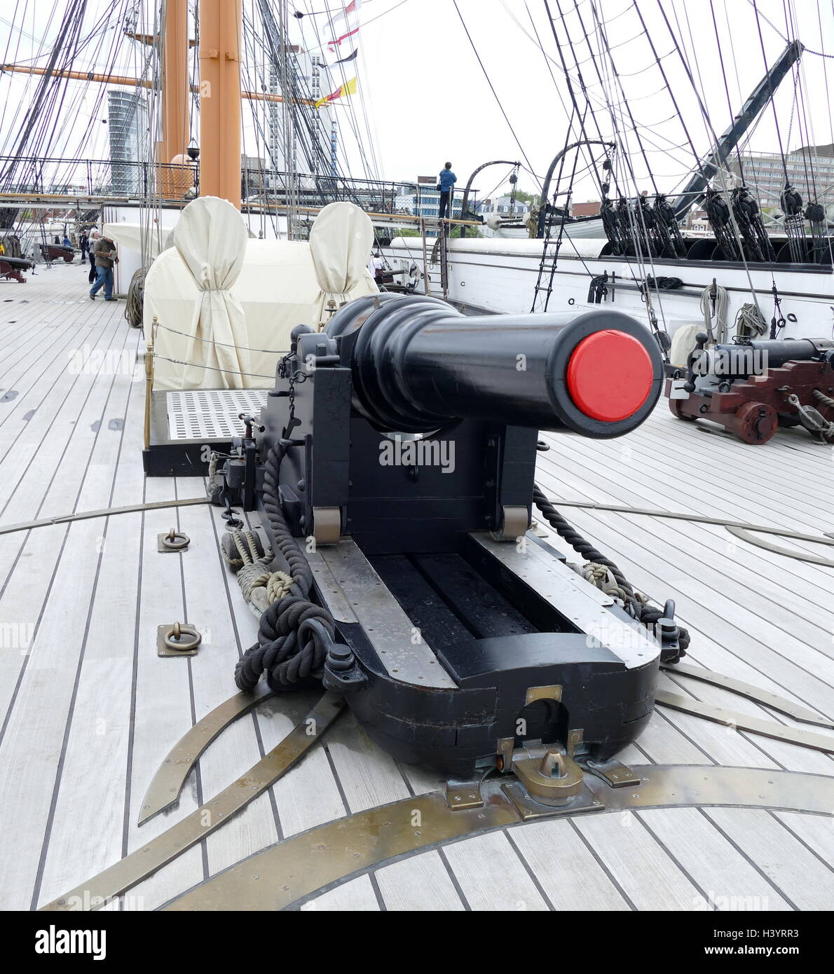 Cannon on the deck of HMS Warrior; the Royal Navy's first ironclad ocean-going armoured battleship, and was launched in 1860. She became a depot ship in 1902, was renamed HMS Vernon III in 1904 Stock Photo