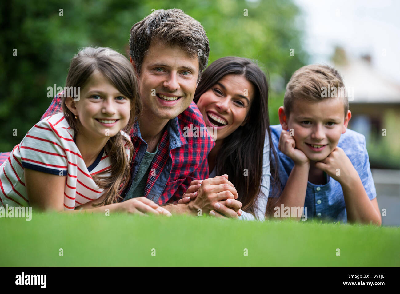 Portrait of happy family lying in park Stock Photo - Alamy