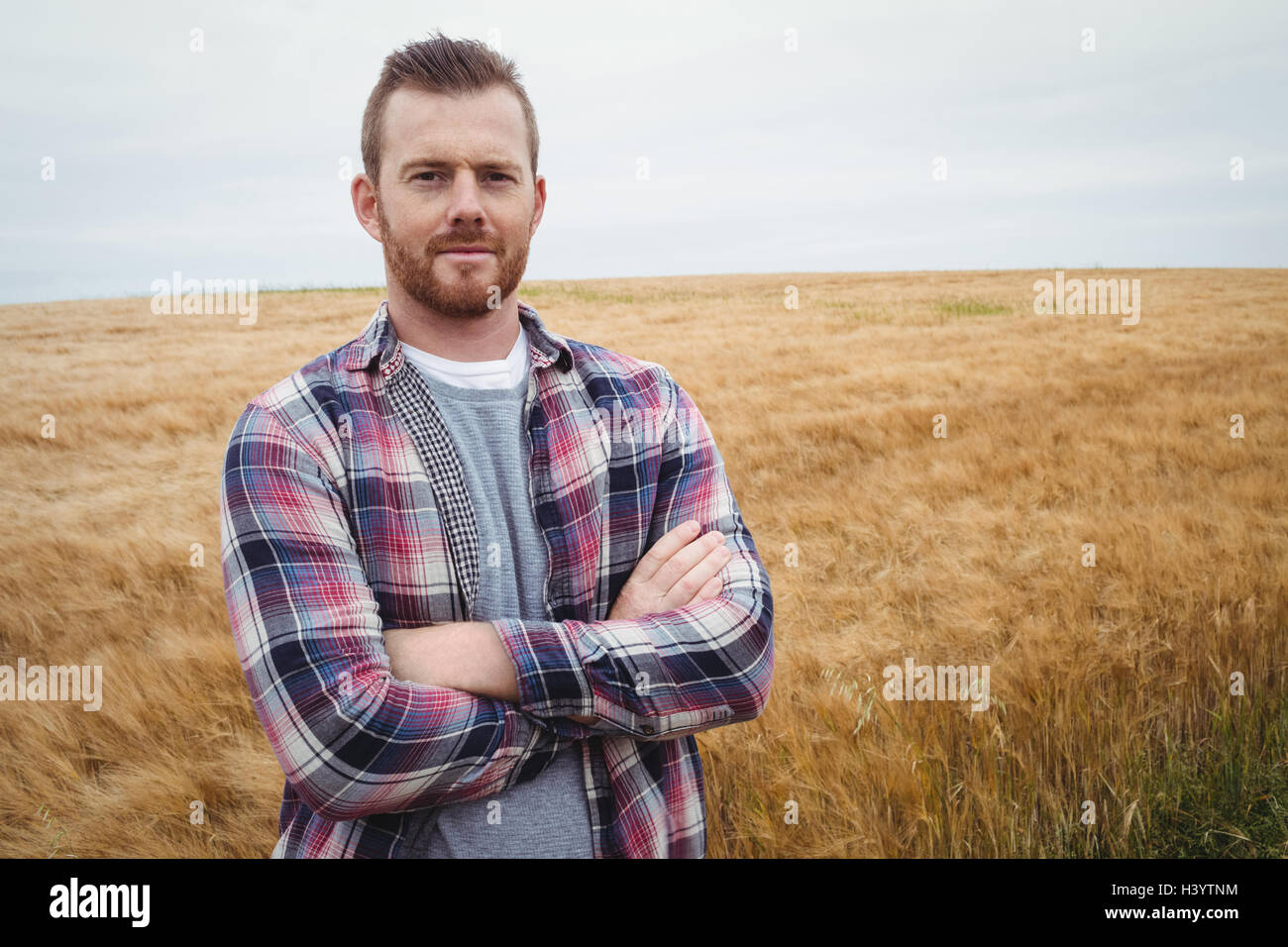 Portrait of farmer standing with arms crossed in the field Stock Photo ...