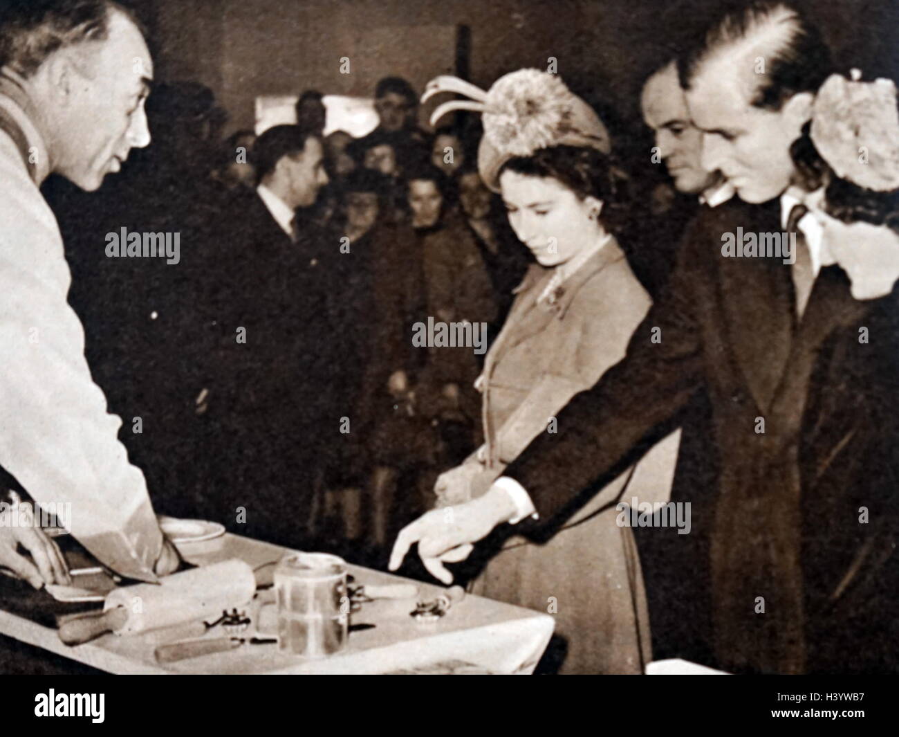 Photograph of Queen Elizabeth II and Prince Philip, Duke of Edinburgh at the Pastry Making Exhibit at Olympia. Dated 20th Century Stock Photo