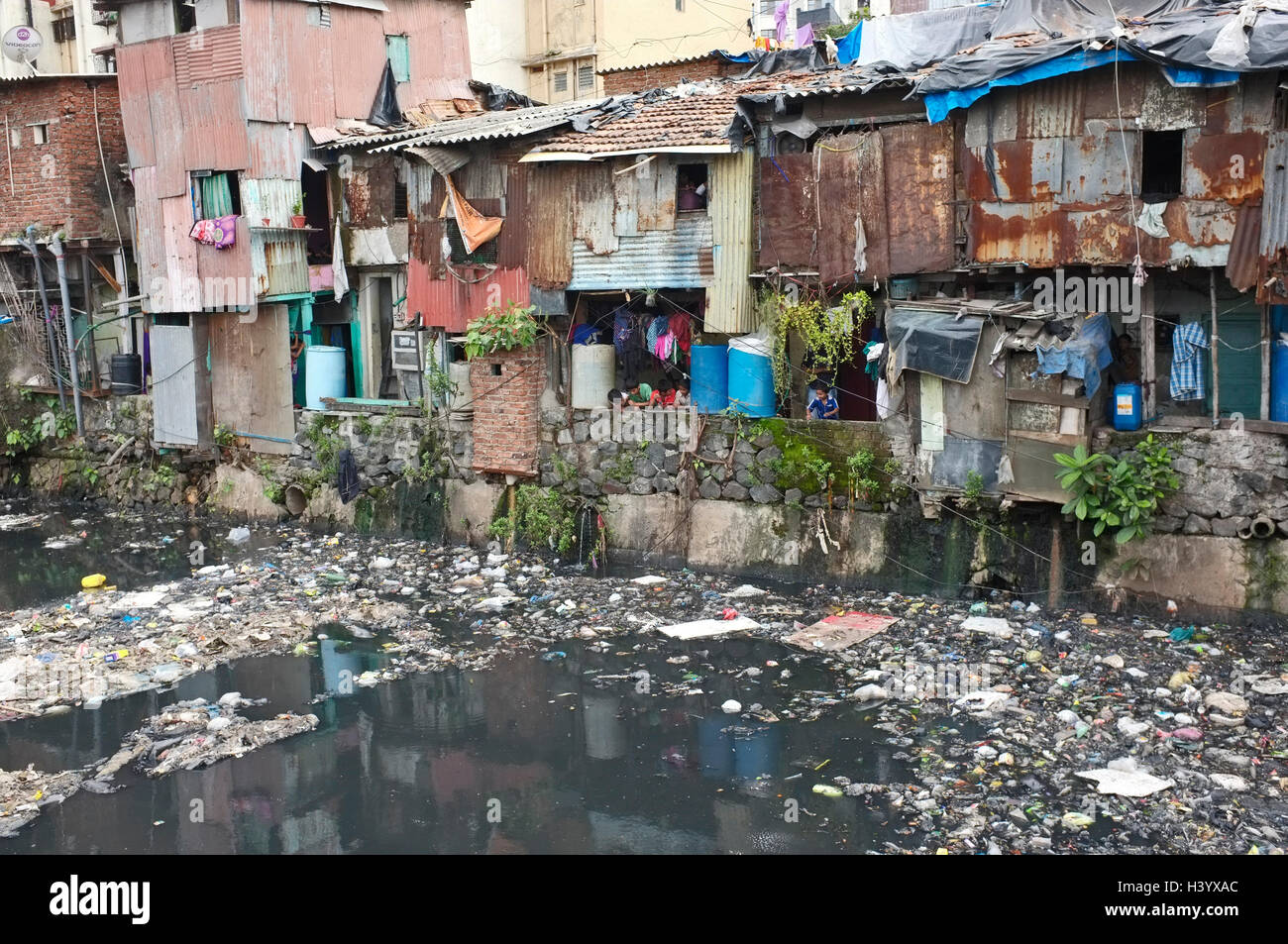 sewerage and plastic pollution next to slum housing , dharavi slum, mumbai, Maharashtra, india Stock Photo