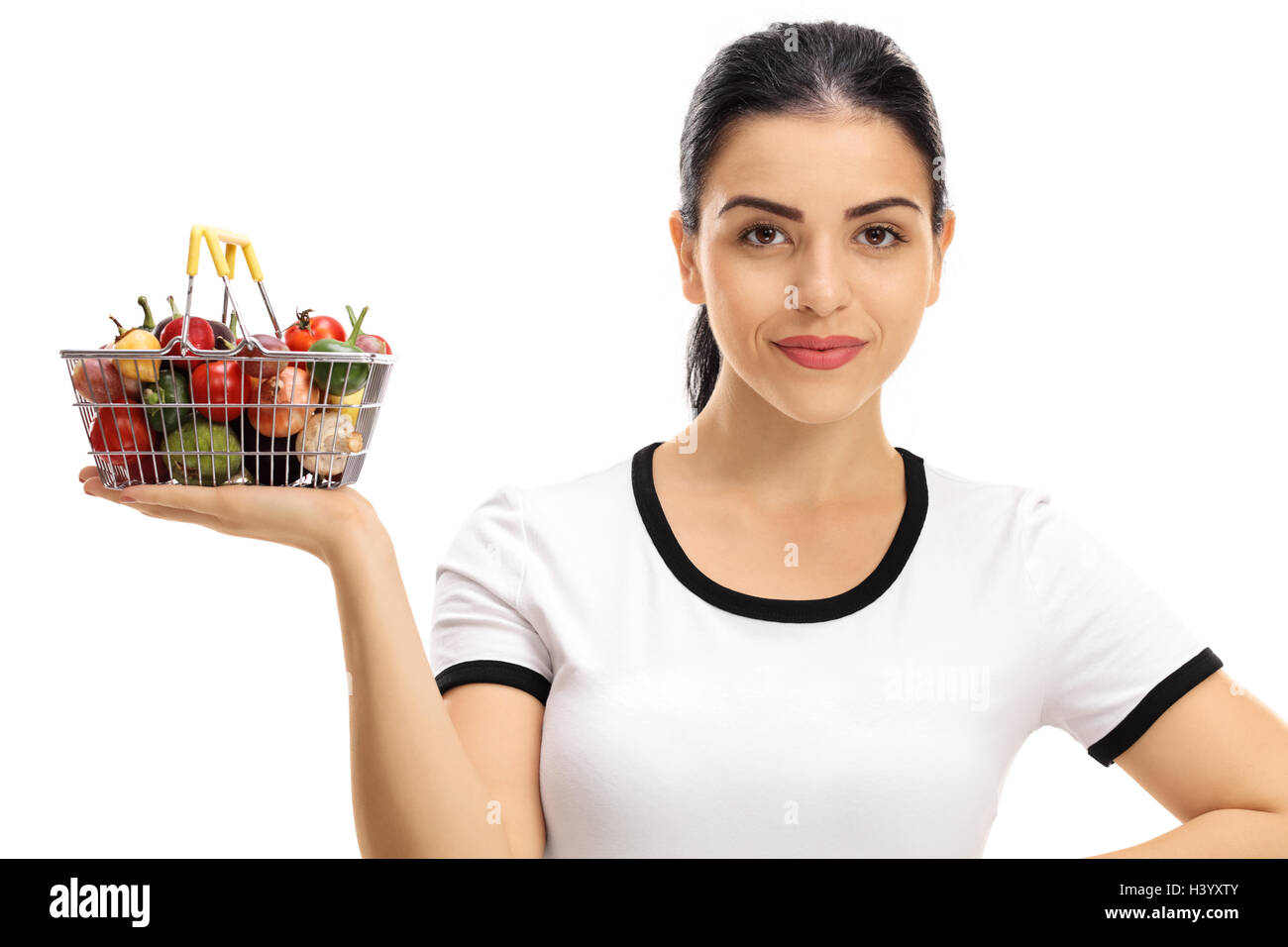 Young woman holding a small shopping basket full of fruits and ...