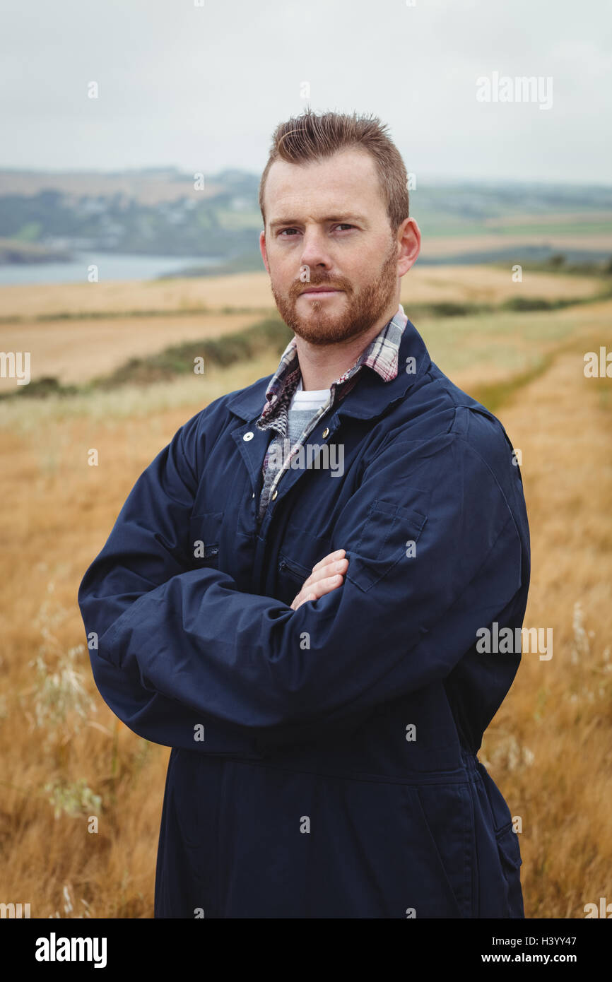 Portrait of farmer standing with arms crossed in the field Stock Photo ...