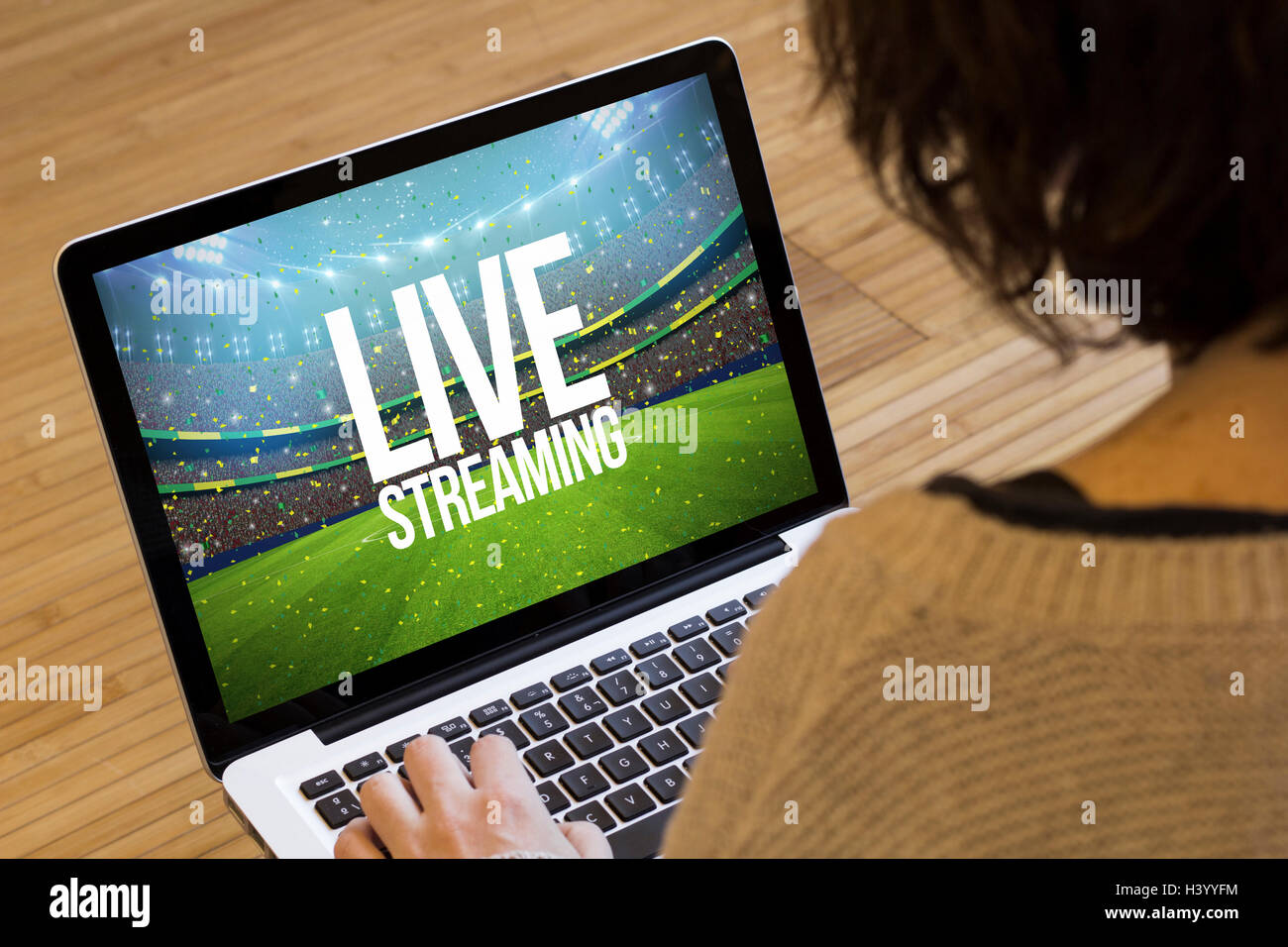 live streaming concept: live streaming text on a stadium on a laptop screen. Screen graphics are made up. Stock Photo