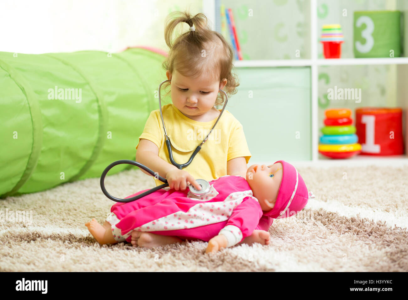 Child Girl Playing With A Doll In Playroom Stock Photo - Alamy