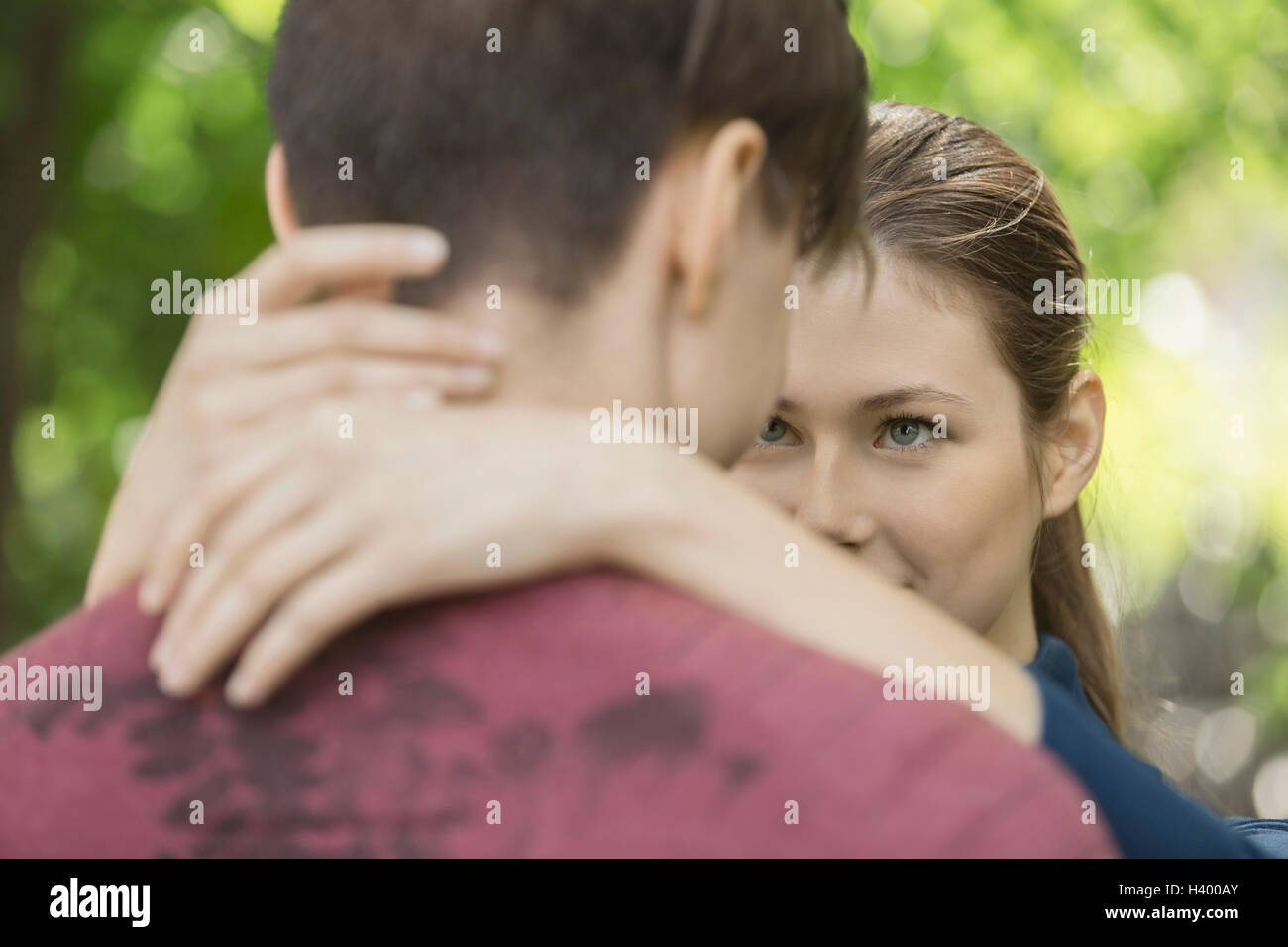 Woman looking at boyfriend while embracing in park Stock Photo
