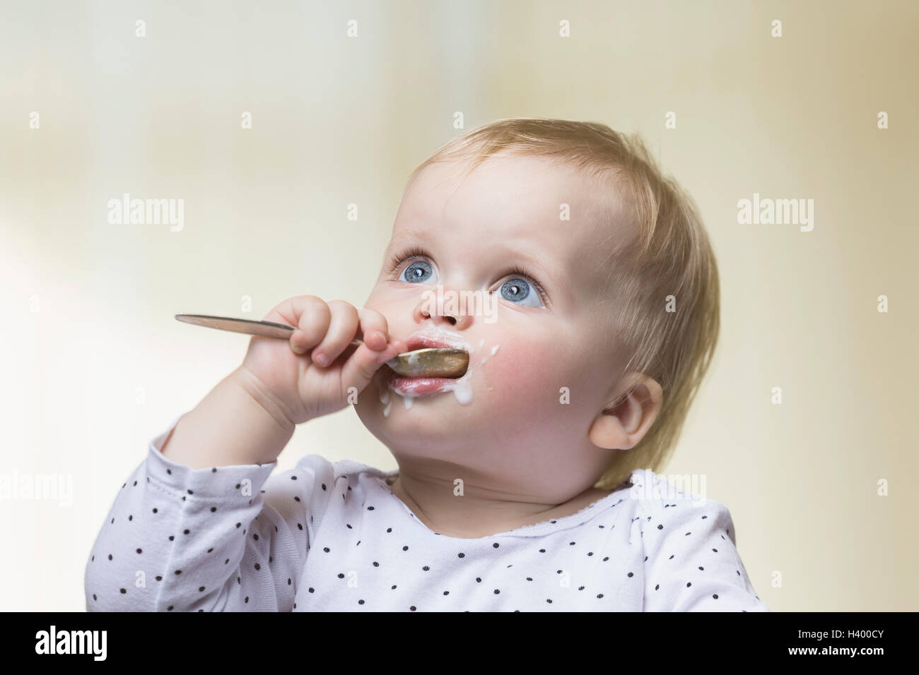Close-up of girl with messy face holding spoon in mouth Stock Photo