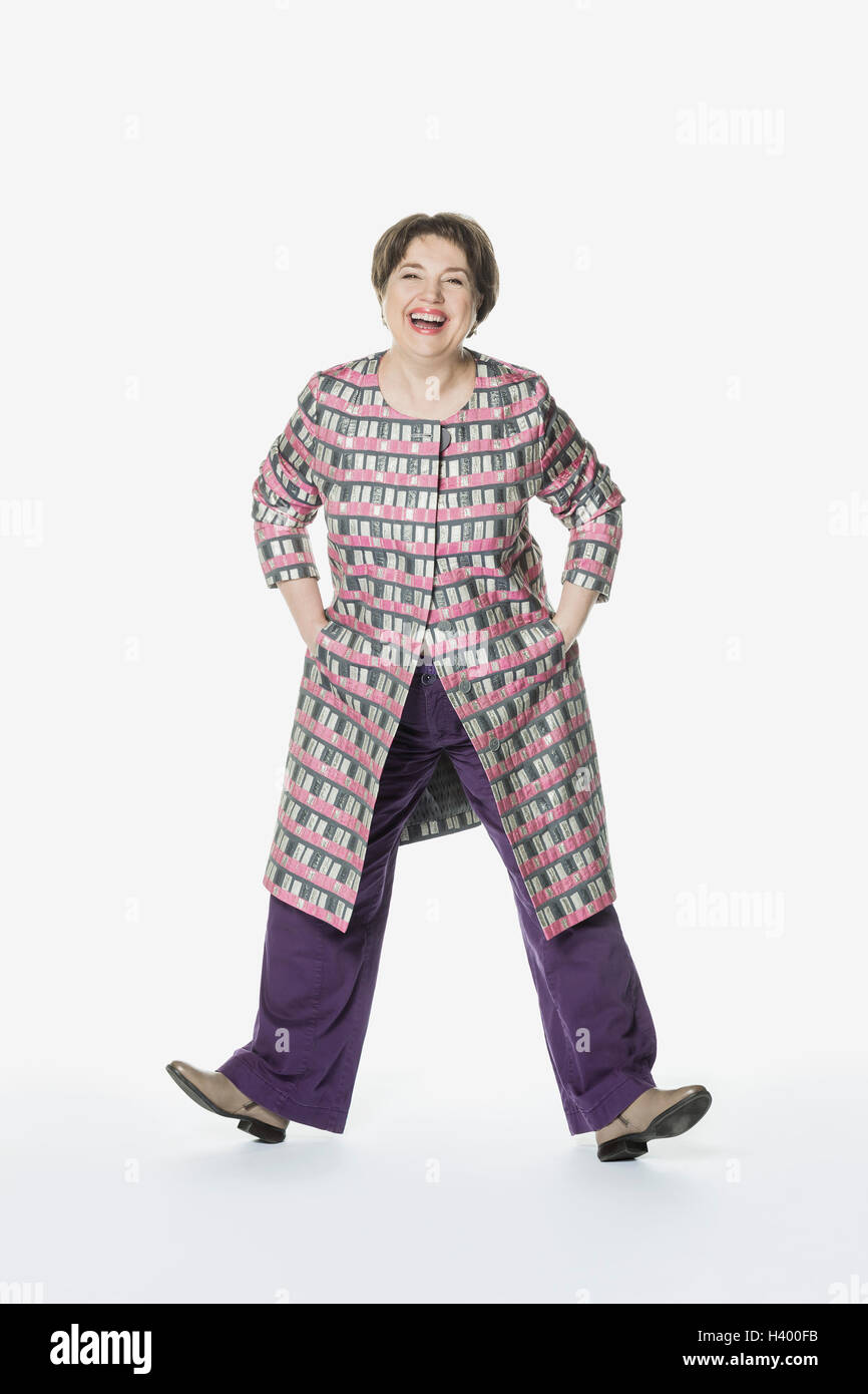 Full length of happy woman standing with hands in pockets against white ...