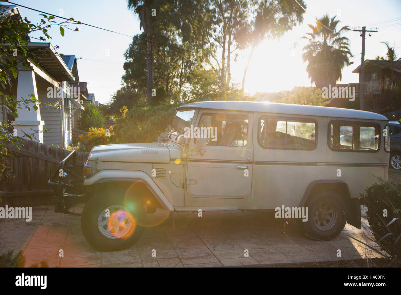 Sports utility vehicle parked outside house by trees on sunny day, Melbourne, Victoria, Australia Stock Photo