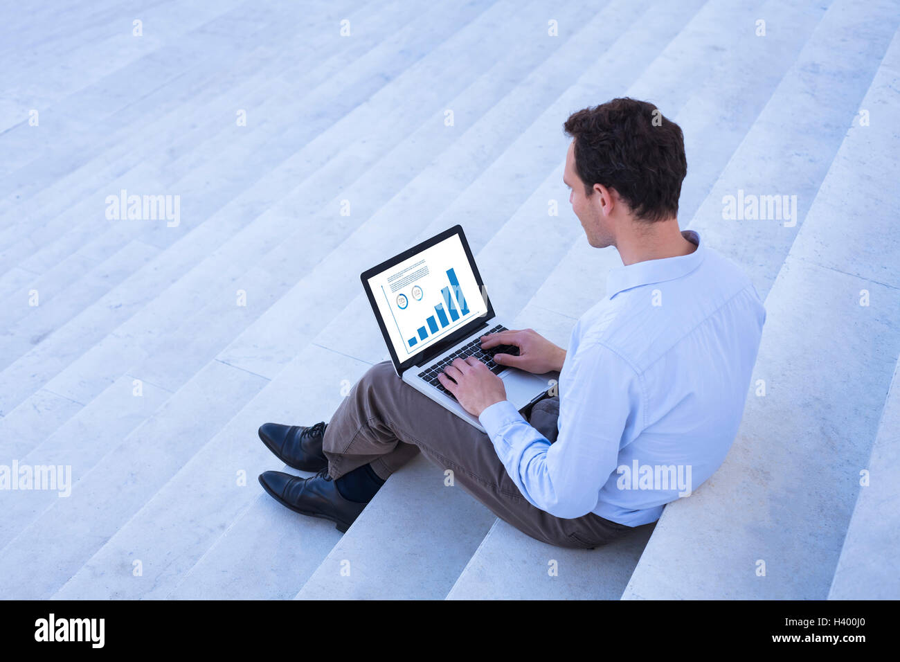 Working on financial data with laptop outdoors Stock Photo