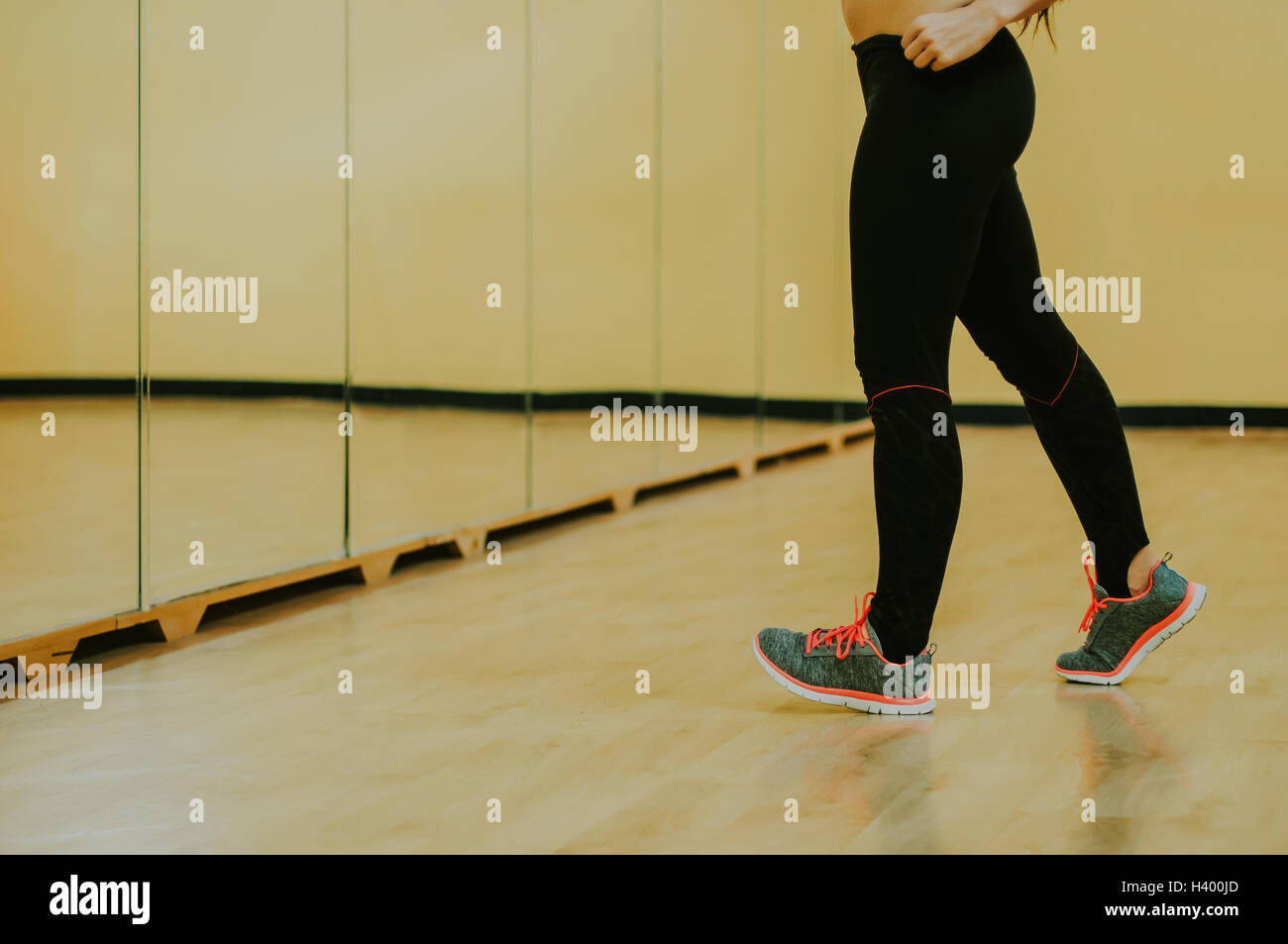 Woman exercising in front of a mirror in a fitness studio Stock Photo